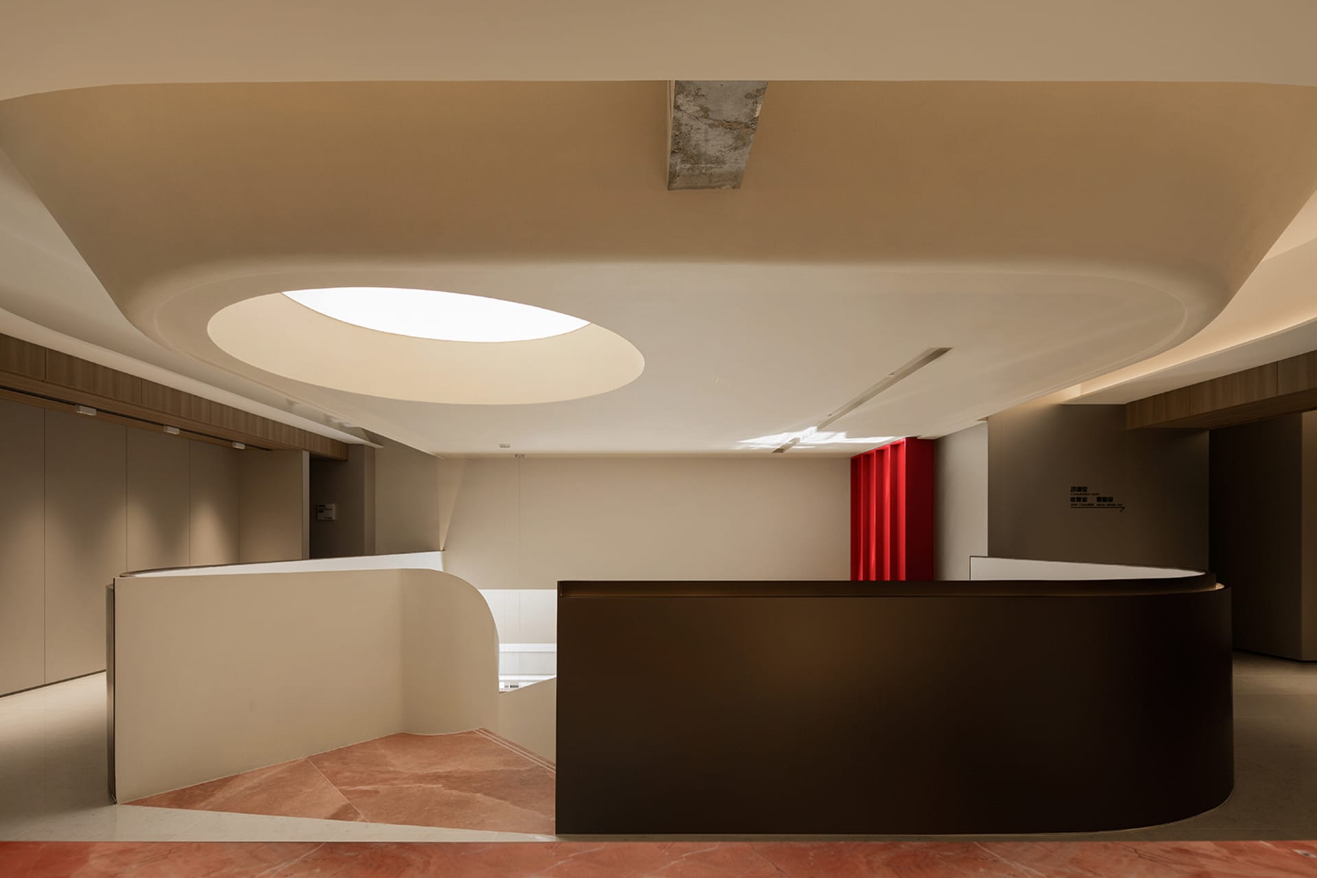 A modern industrial office space featuring sleek concrete walls and a large circular window.