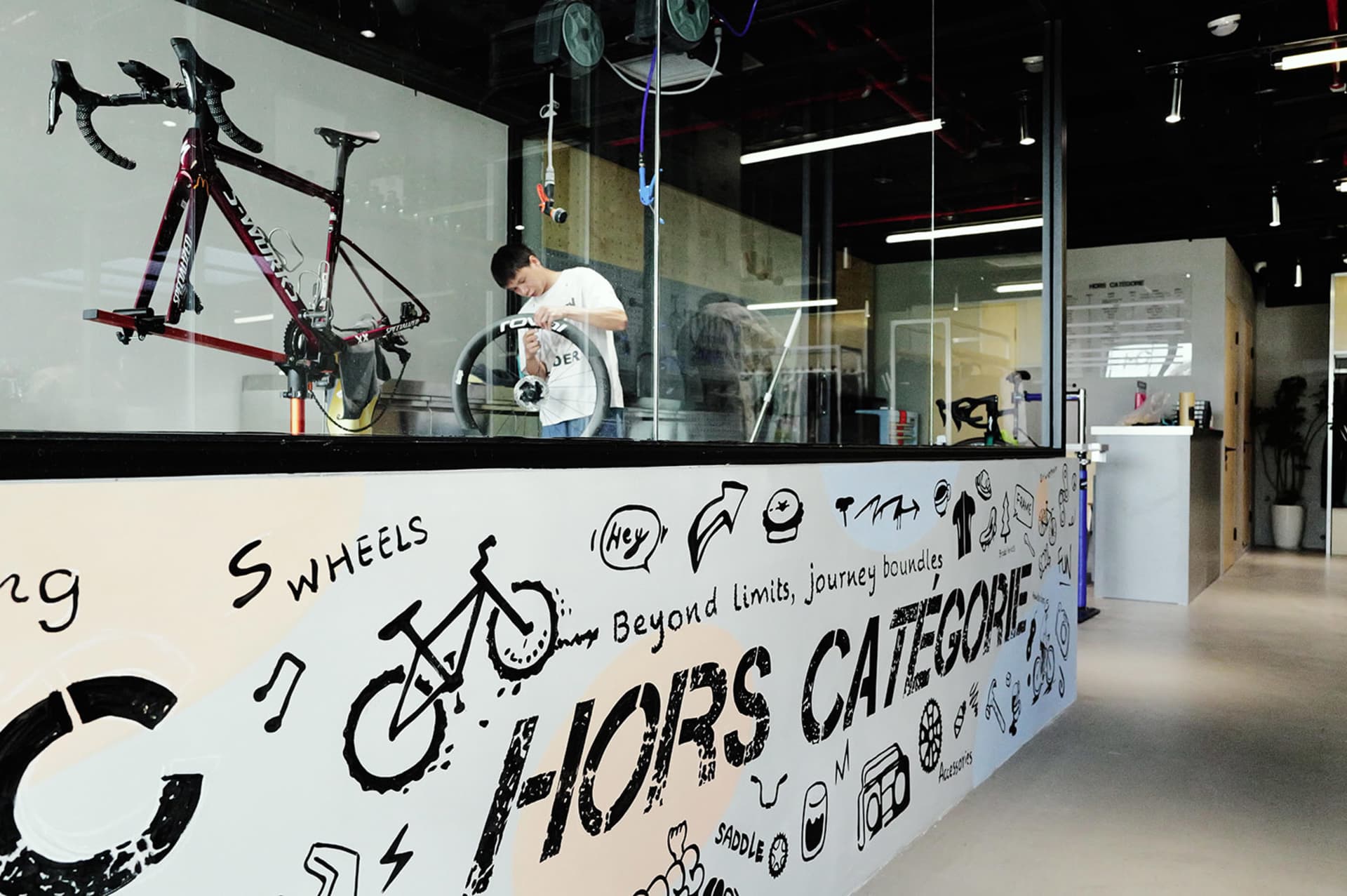 Bike repair shop featuring exposed concrete walls, glass display cases, and metal shelving.