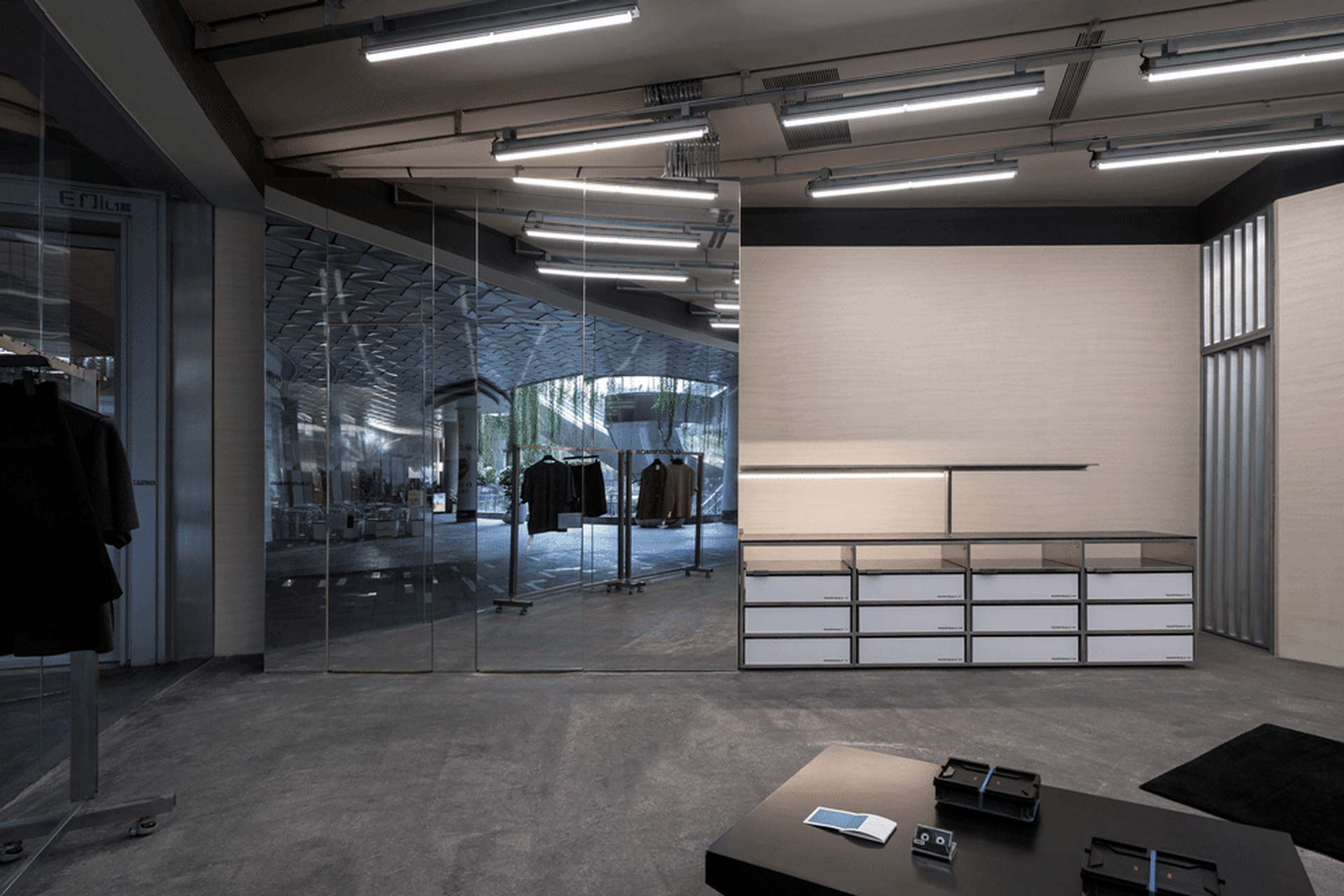 Industrial-style clothing store with metallic fixtures and glass walls.