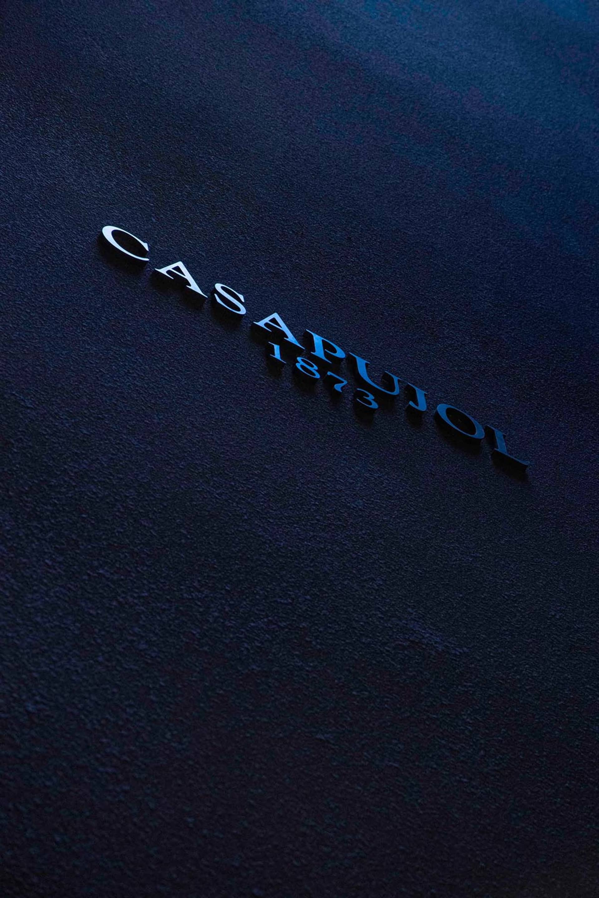 深色背景上的 Casapujol 1873 黑色字母