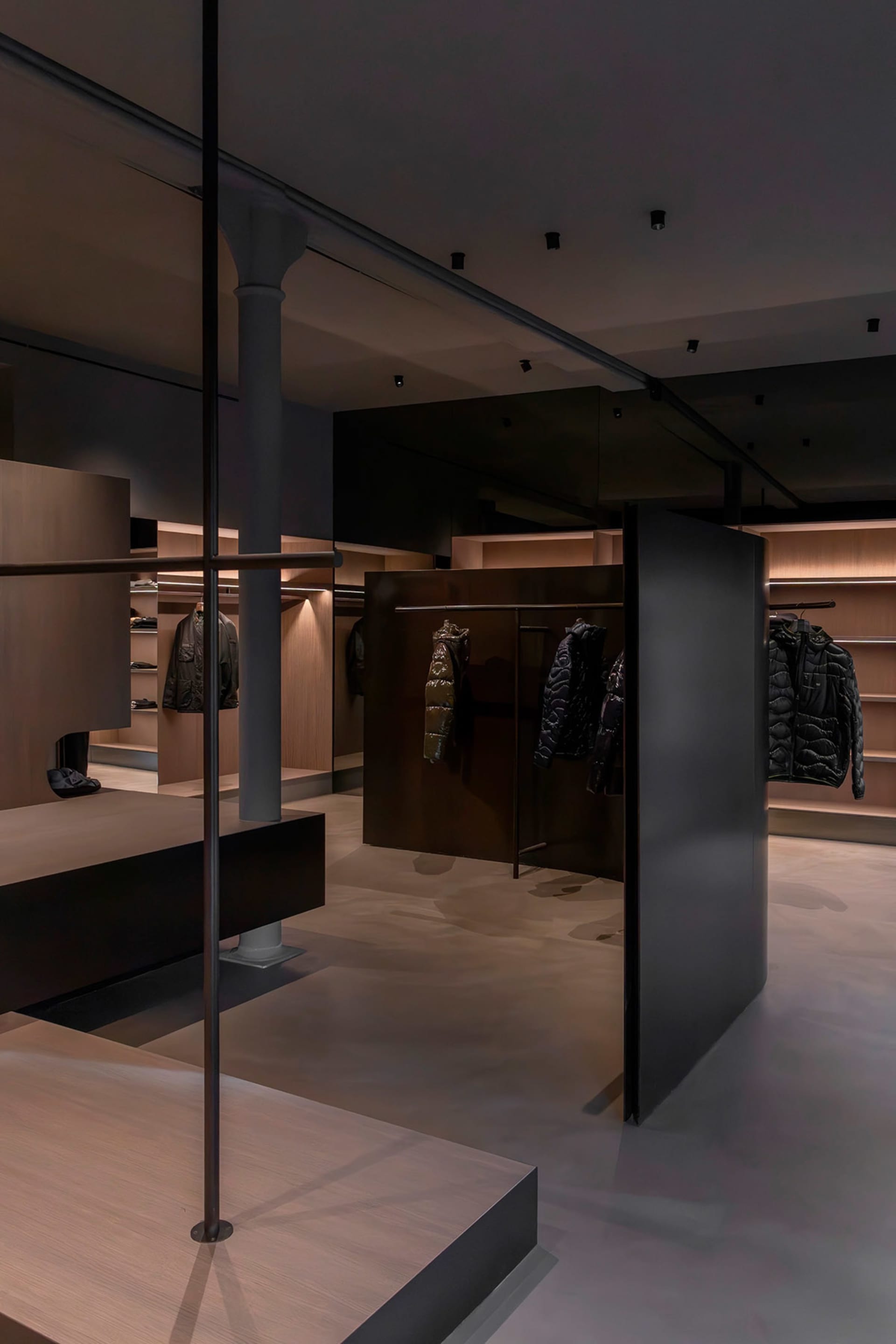 A modern retail store interior with dark walls and illuminated shelves.