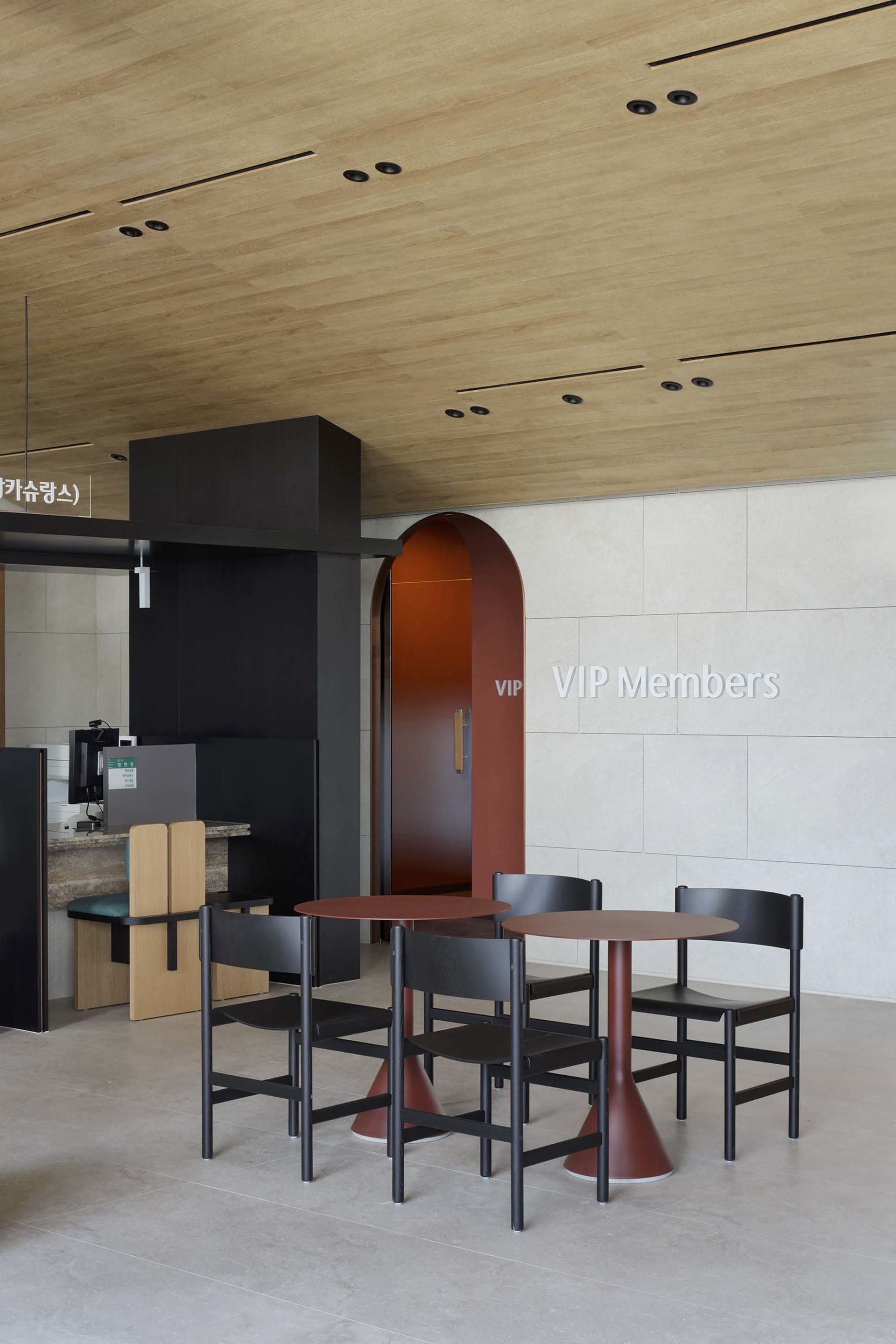 A modern VIP members lobby with metal furniture and a wooden ceiling.