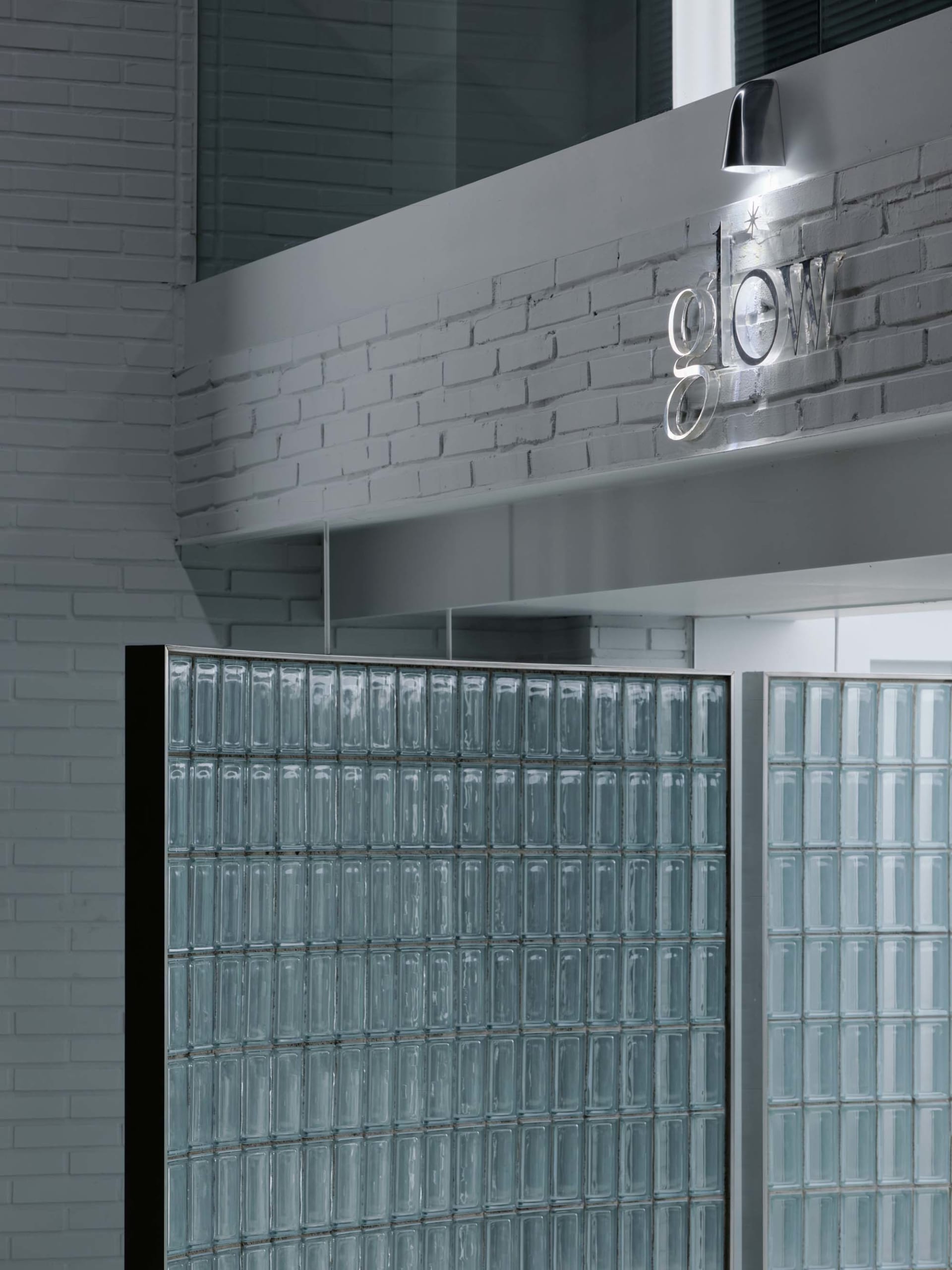 Industrial marketing office interior with glass block walls, brick accents, and concrete finishes.