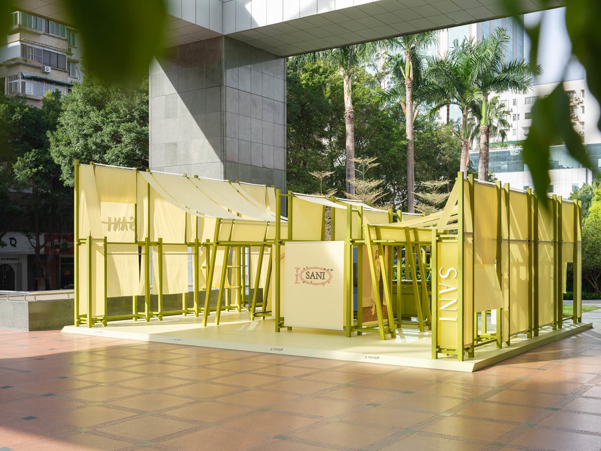 黃色建築空間,搭配布質遮陽篷以及木質與金屬結構元素。