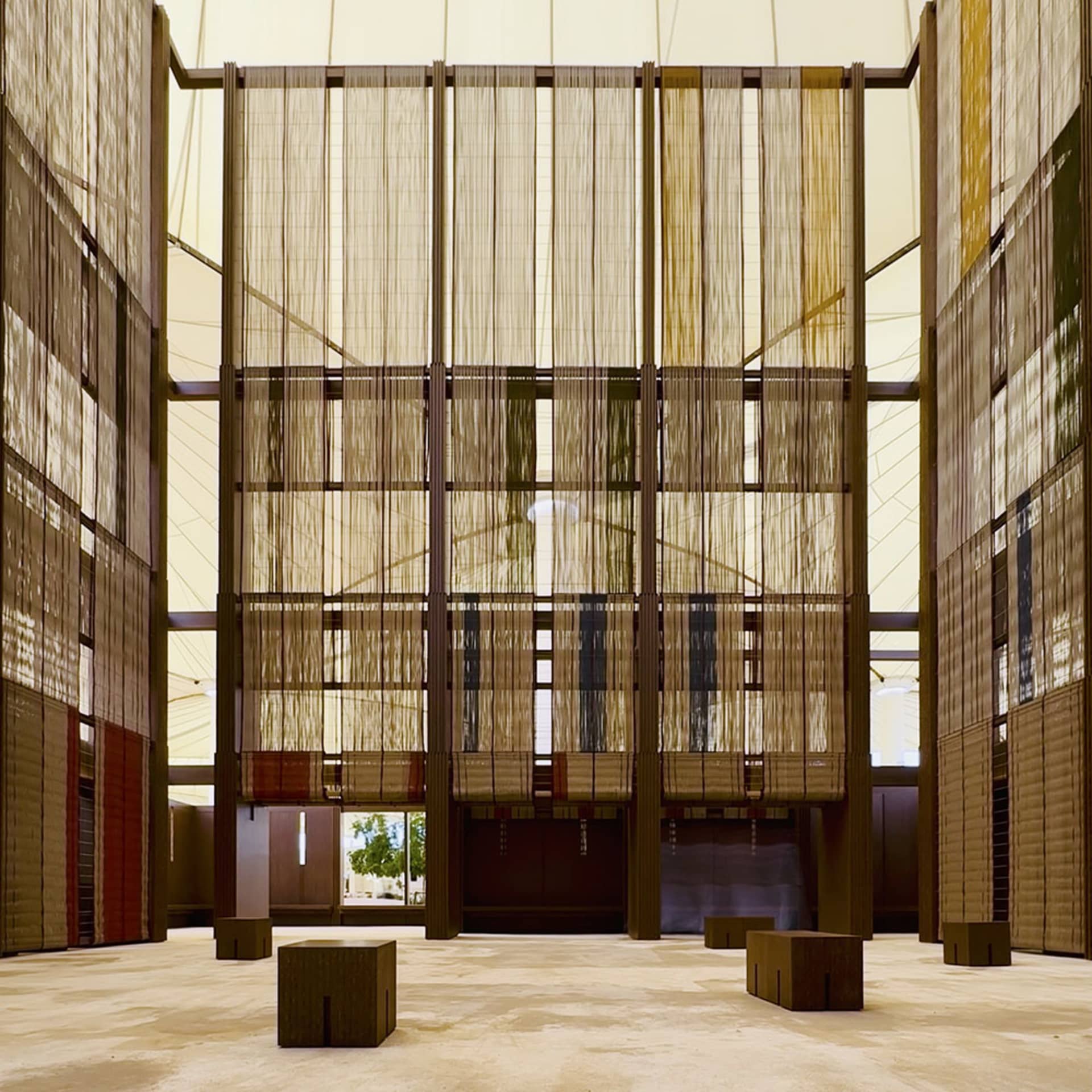 A spacious, modern atrium with textured cloth walls, designed for natural light and open space.