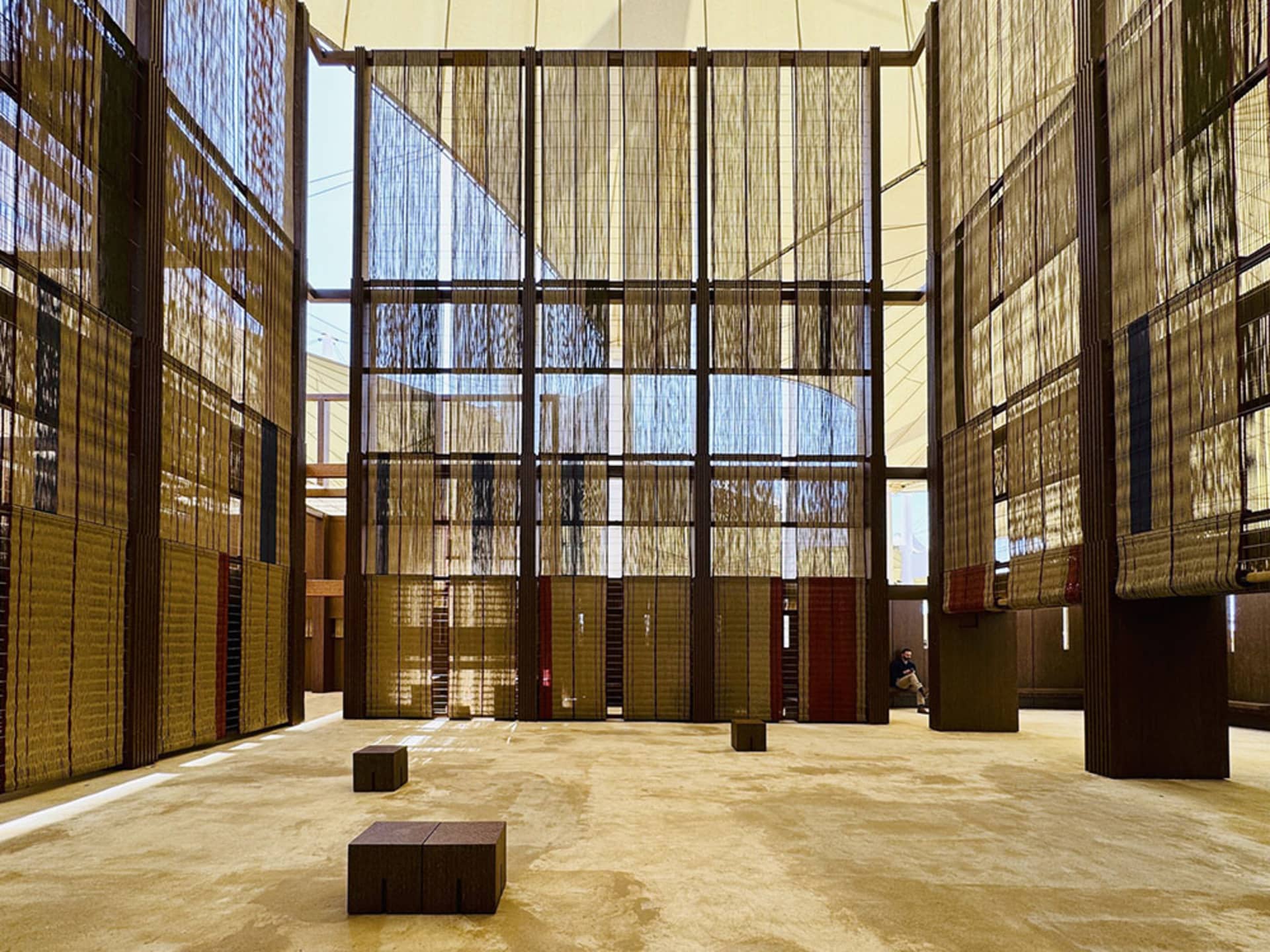 A spacious, modern library with textile partitions and wooden flooring.
