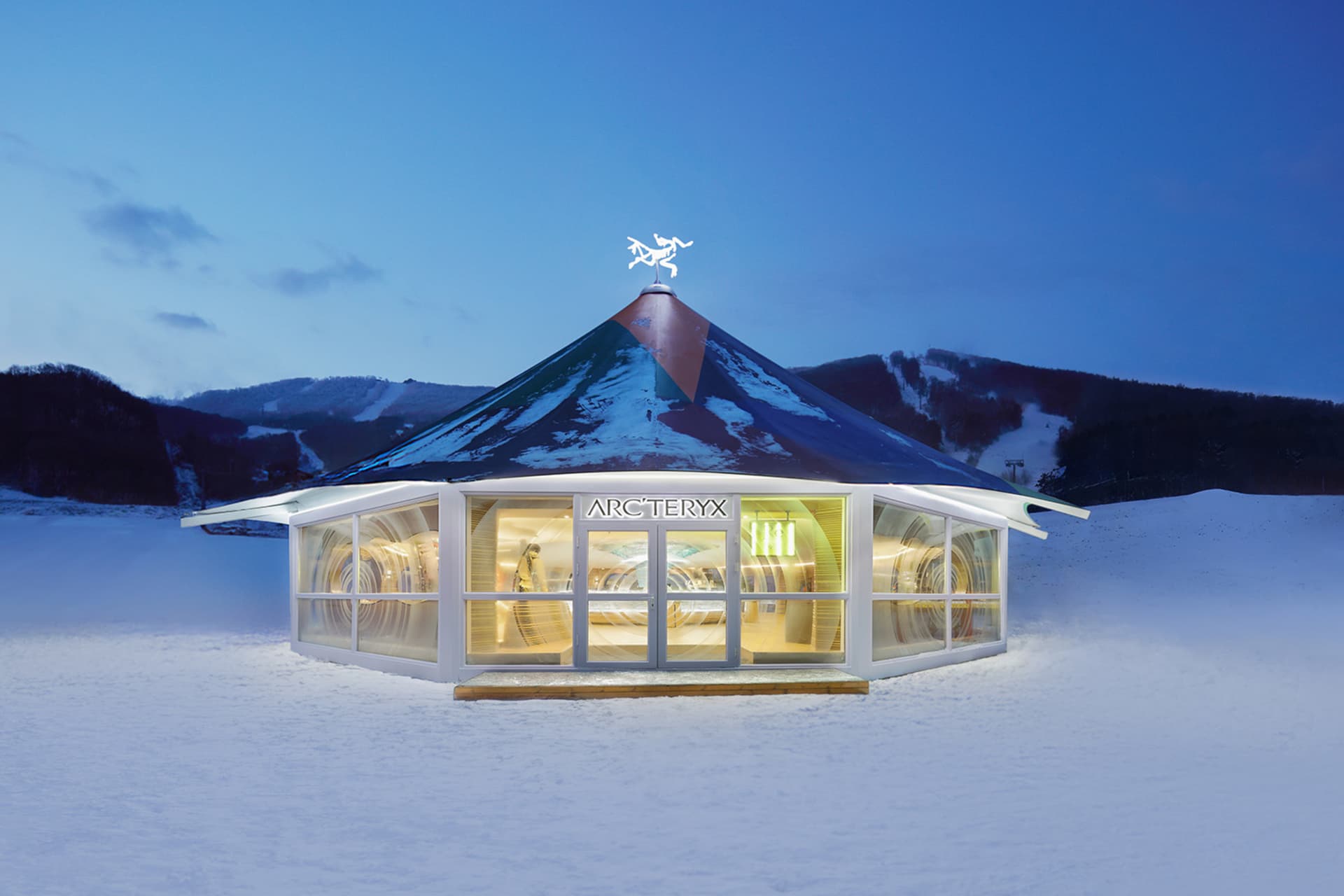 現代零售店擁有玻璃牆與金屬屋頂，坐落於雪景之中