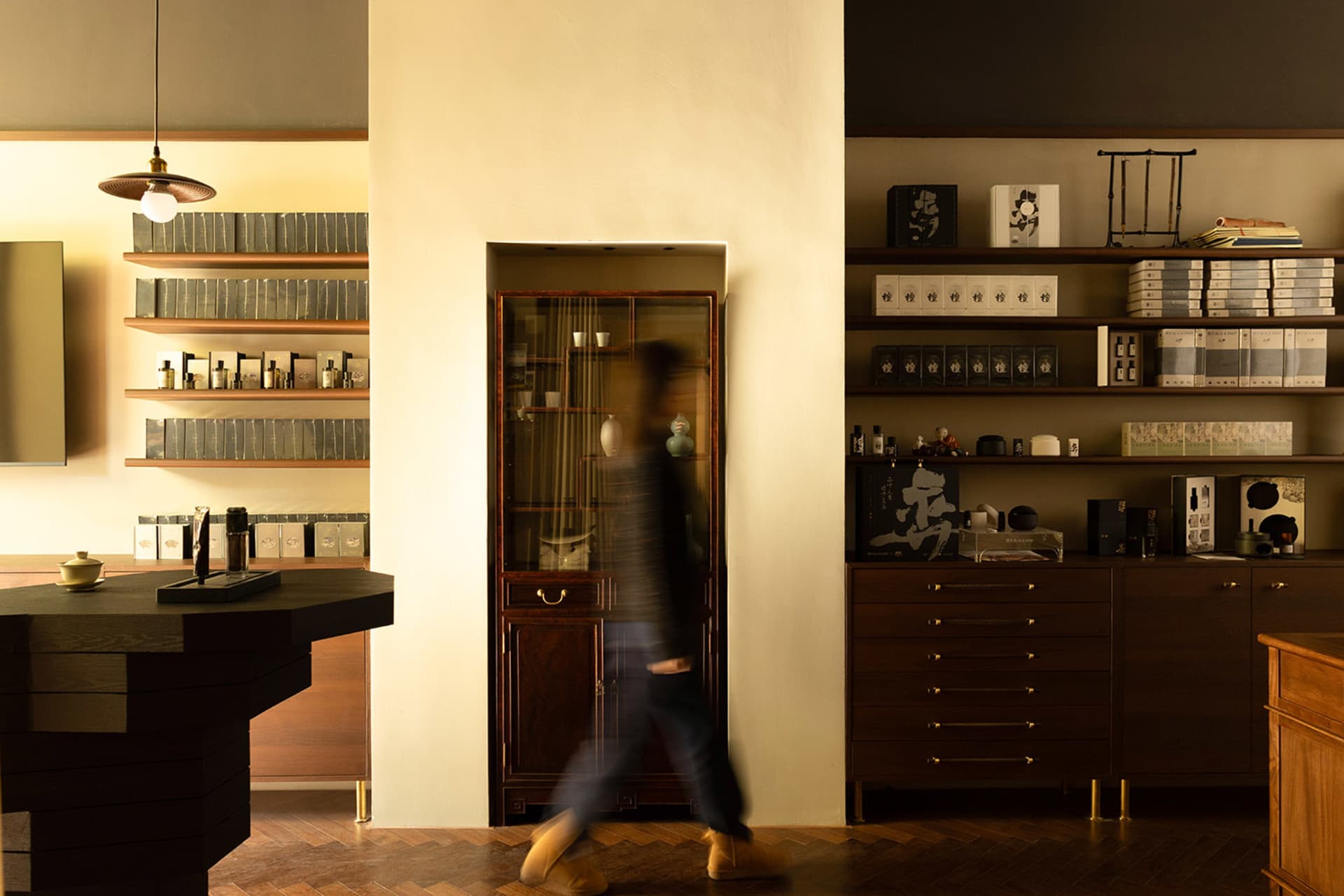 A modern retail storefront featuring a wooden and leather bar counter with glass display cases and shelves.