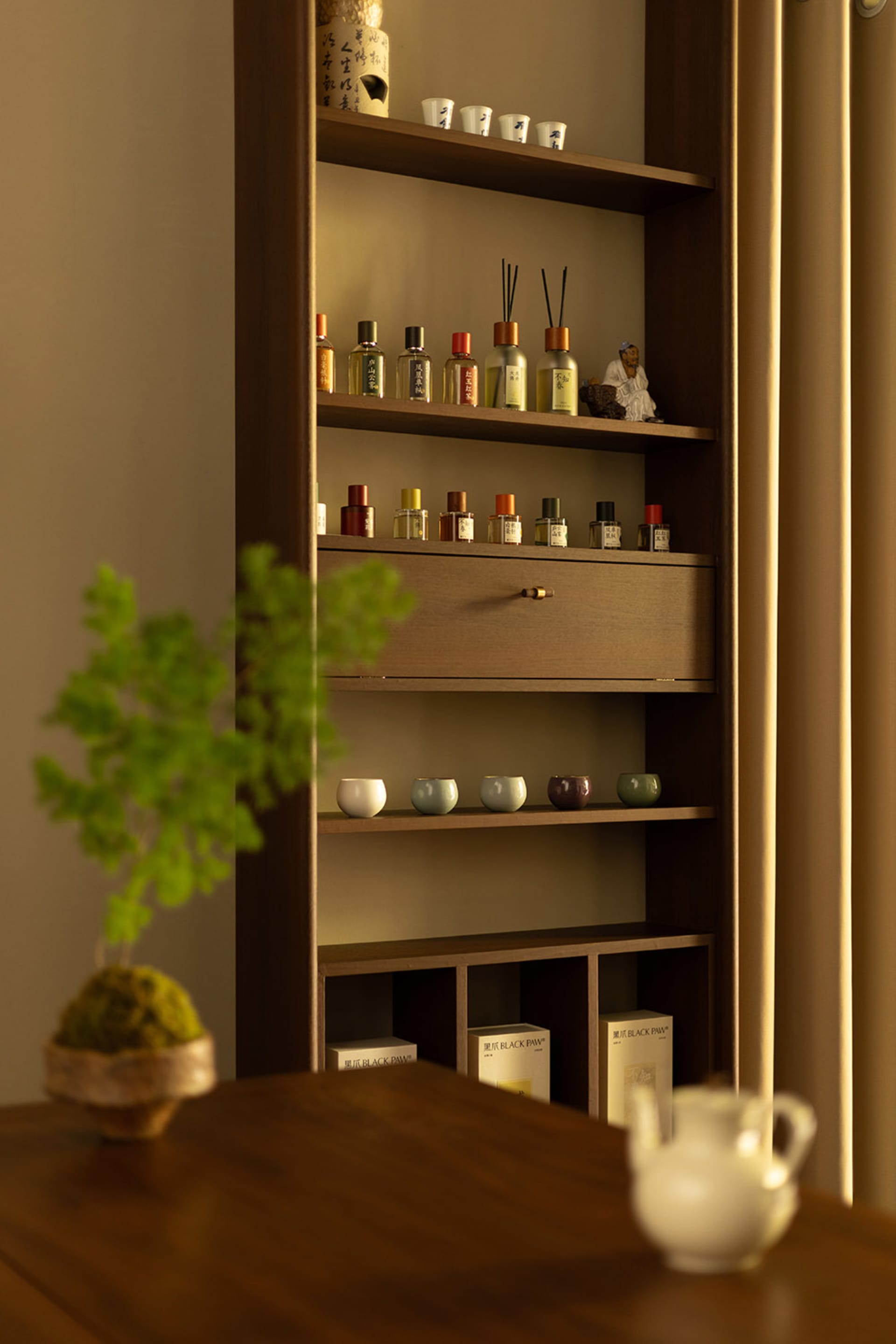 A modern storage shelf made of natural wood with multiple shelves and compartments.