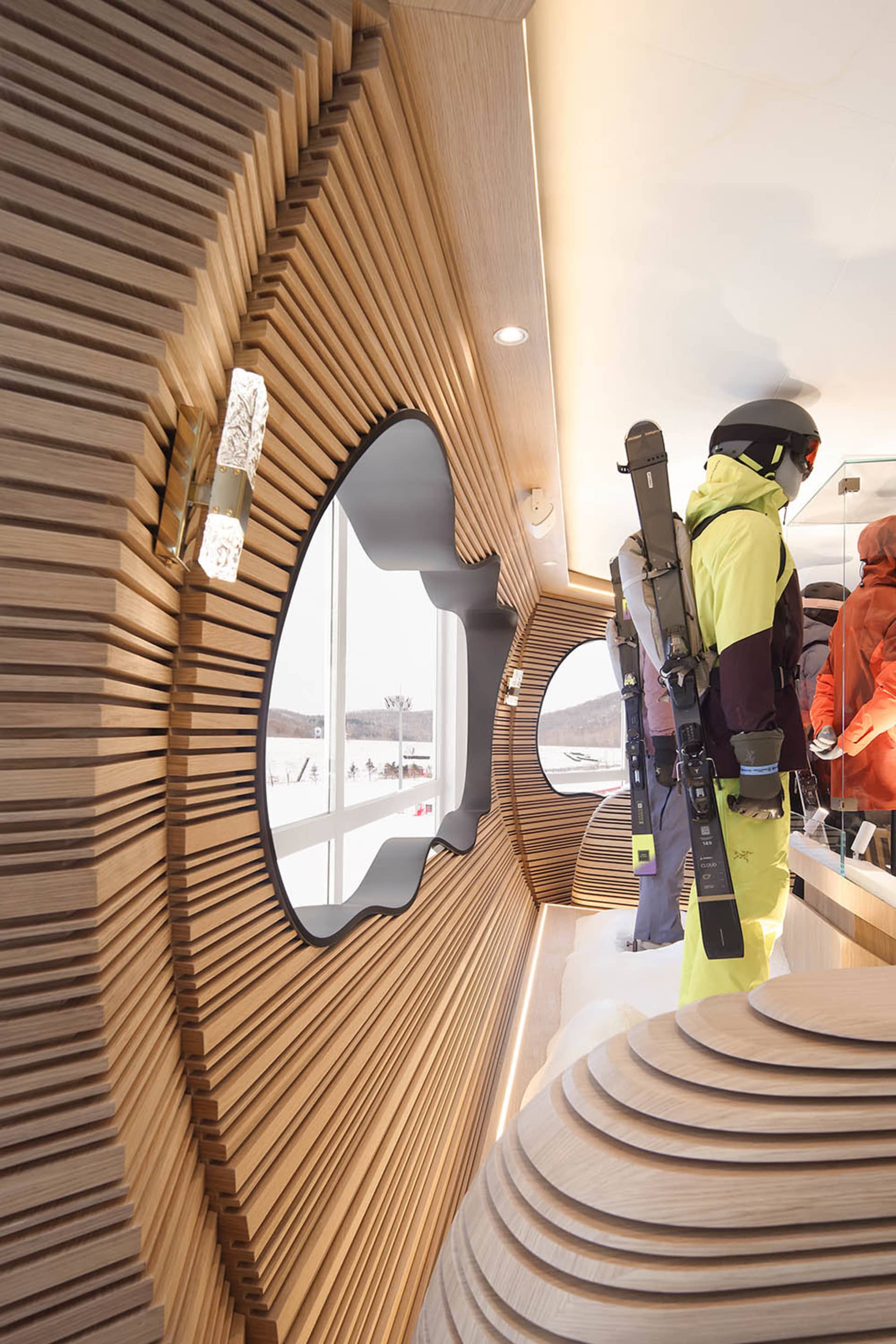 Modern industrial retail shop featuring a unique, wave-shaped wood wall with round openings