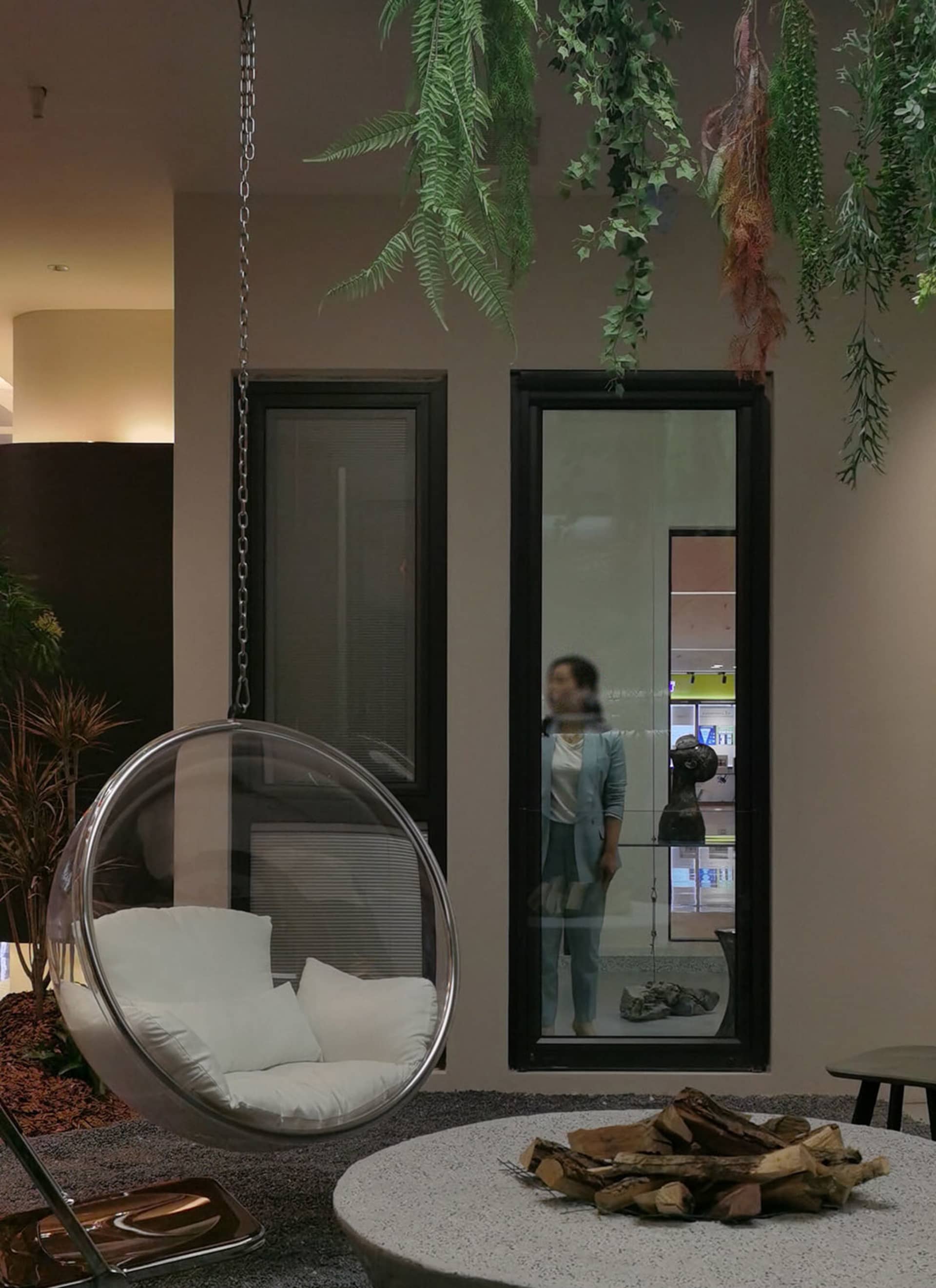 工業風客廳擁有木質地板與家具，搭配懸吊泡泡椅及置有木柴的火坑。
