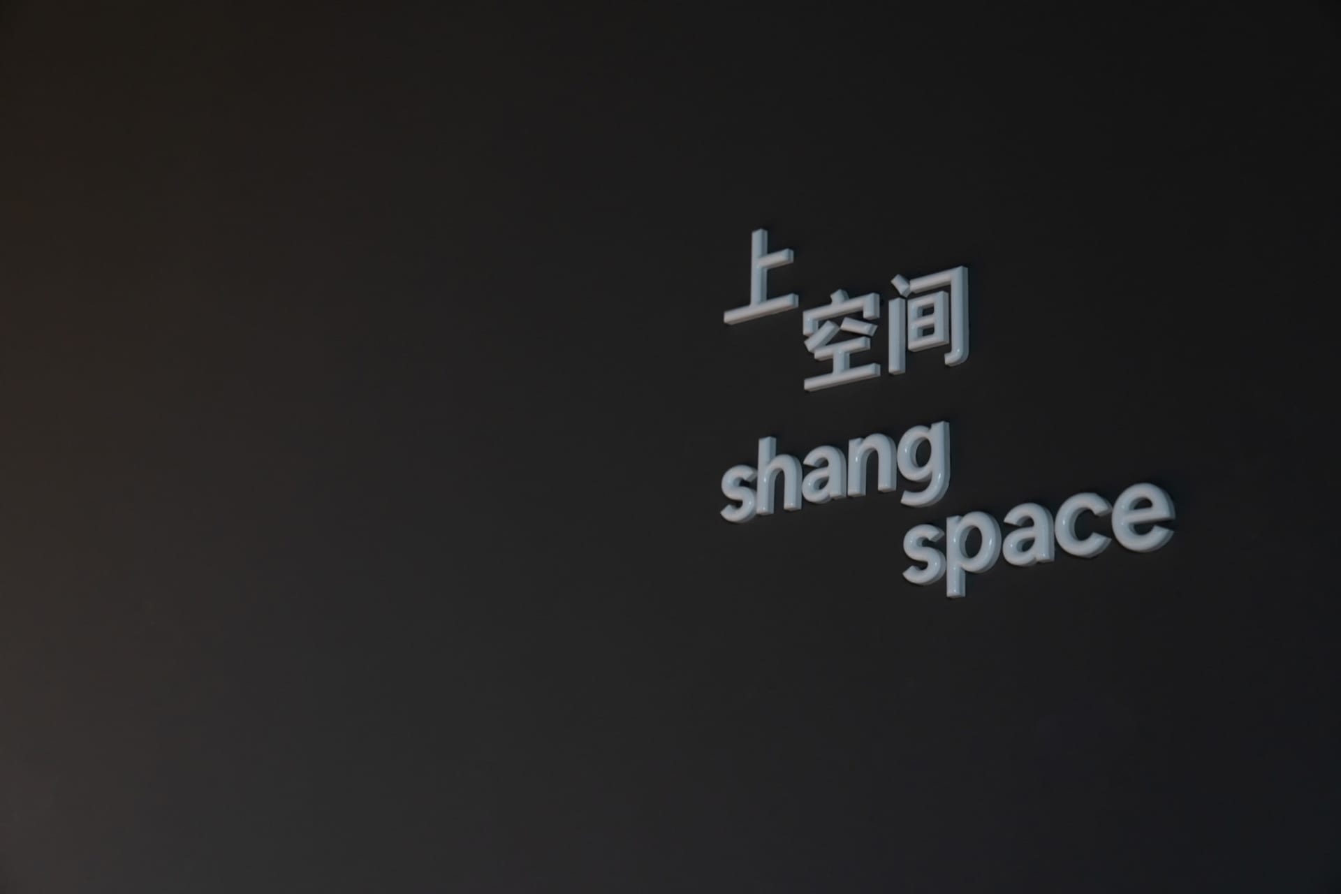 極簡空間，黑牆上寫著「space」與「shang space」字樣。