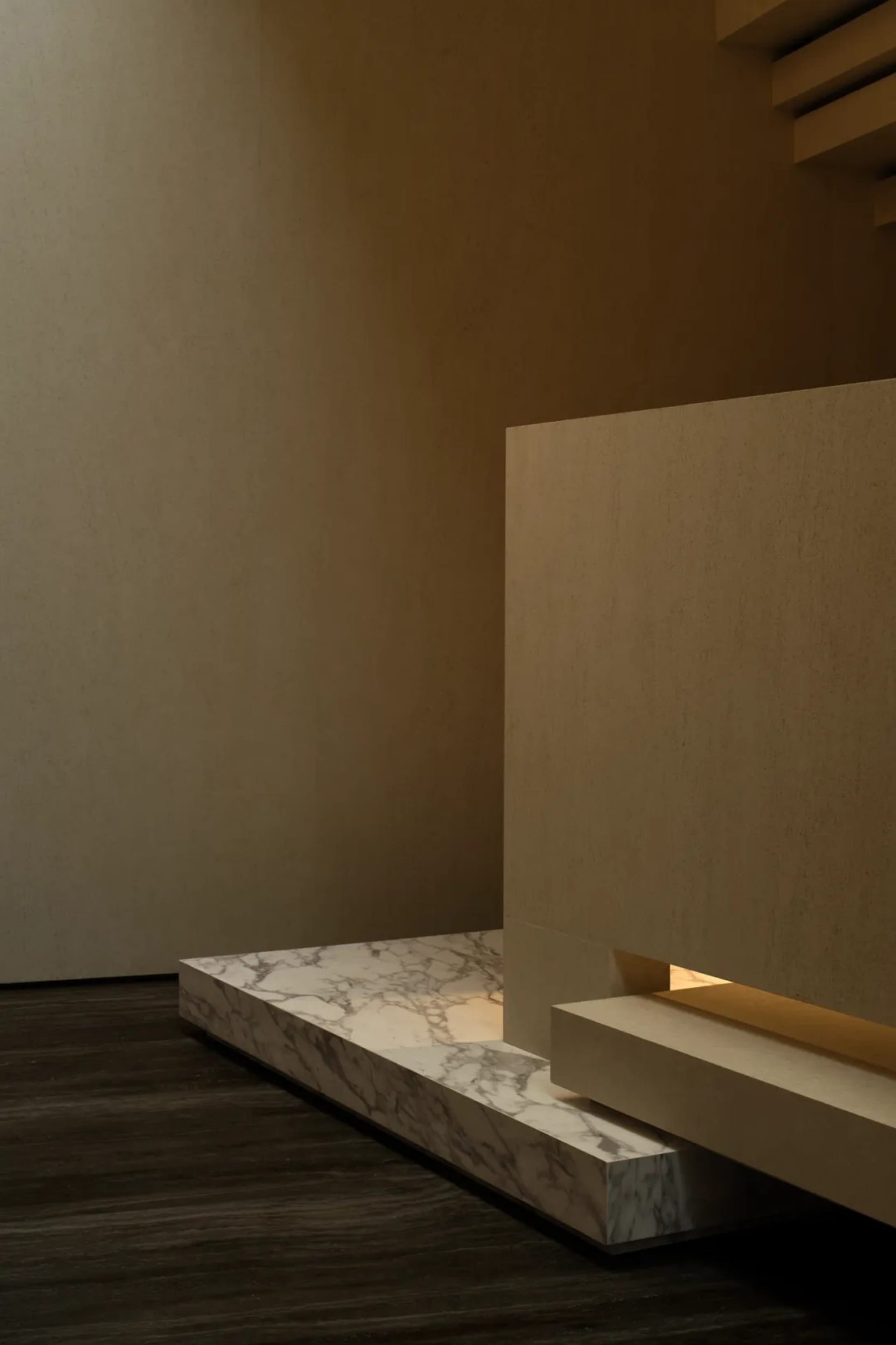 A minimalist staircase with marble steps and a wooden handrail in a modern, neutral-toned interior space.