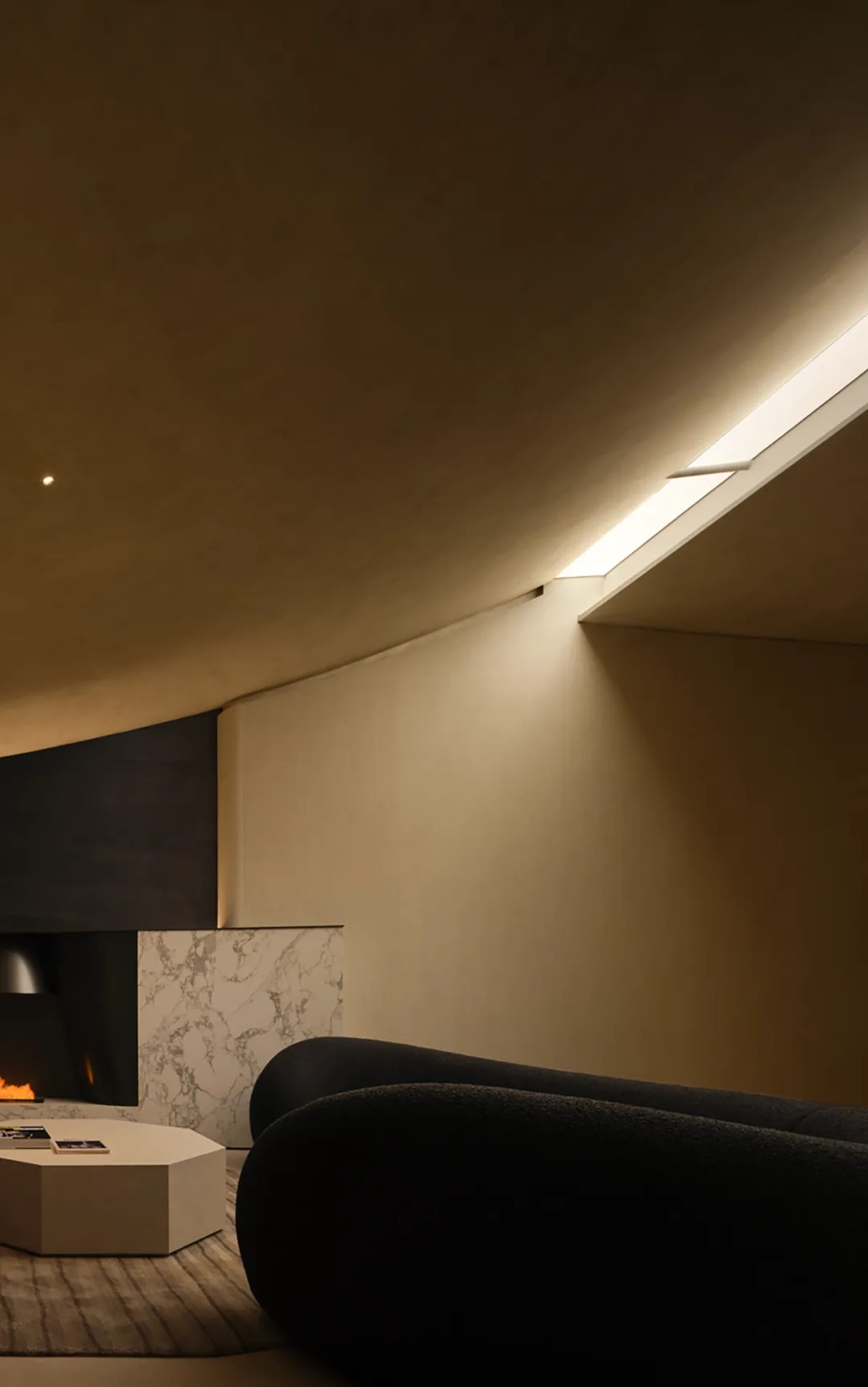 Modern living room featuring concrete and marble surfaces with LED lighting