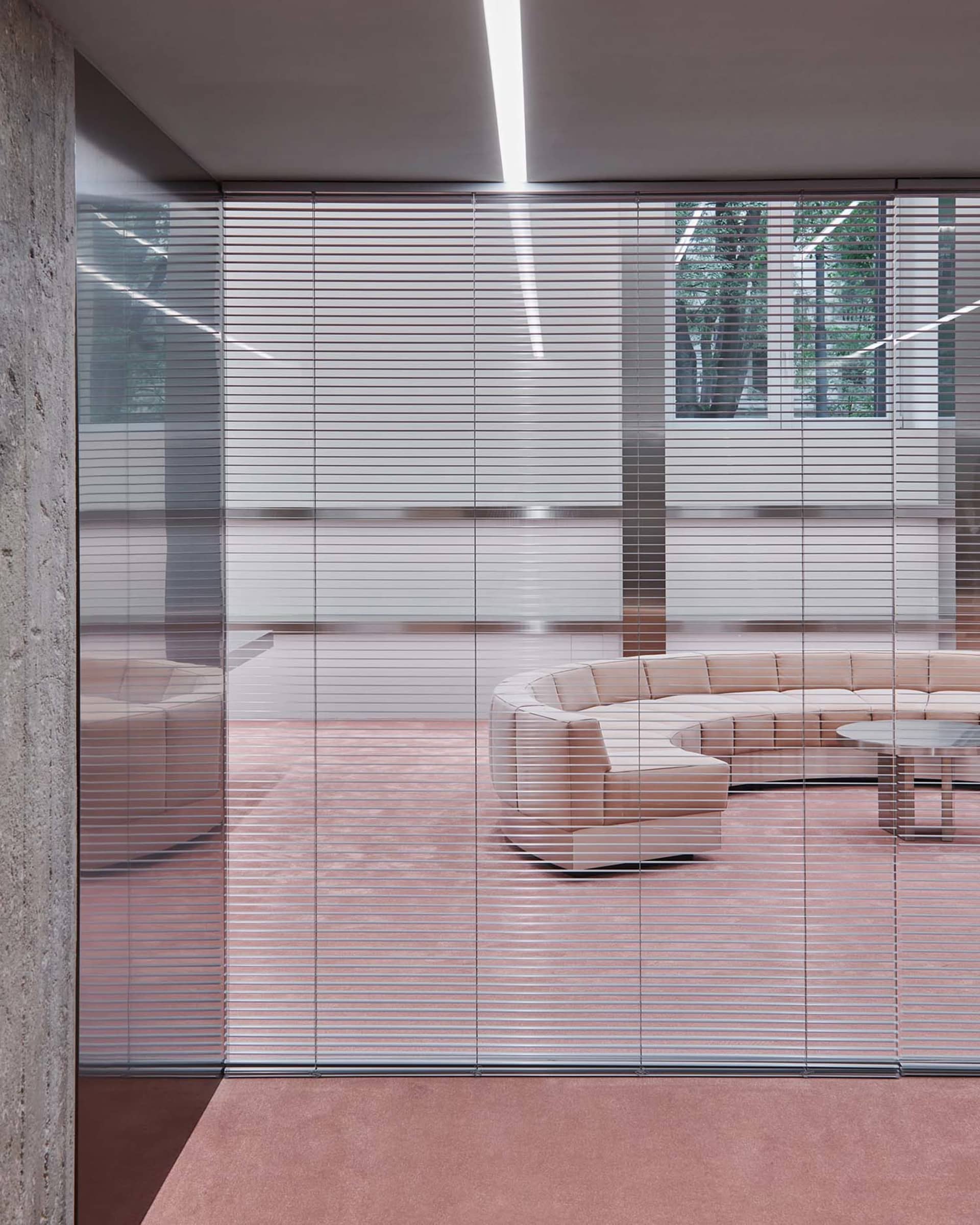 Modern minimalist retail space featuring glass walls, concrete flooring, and metal accents.