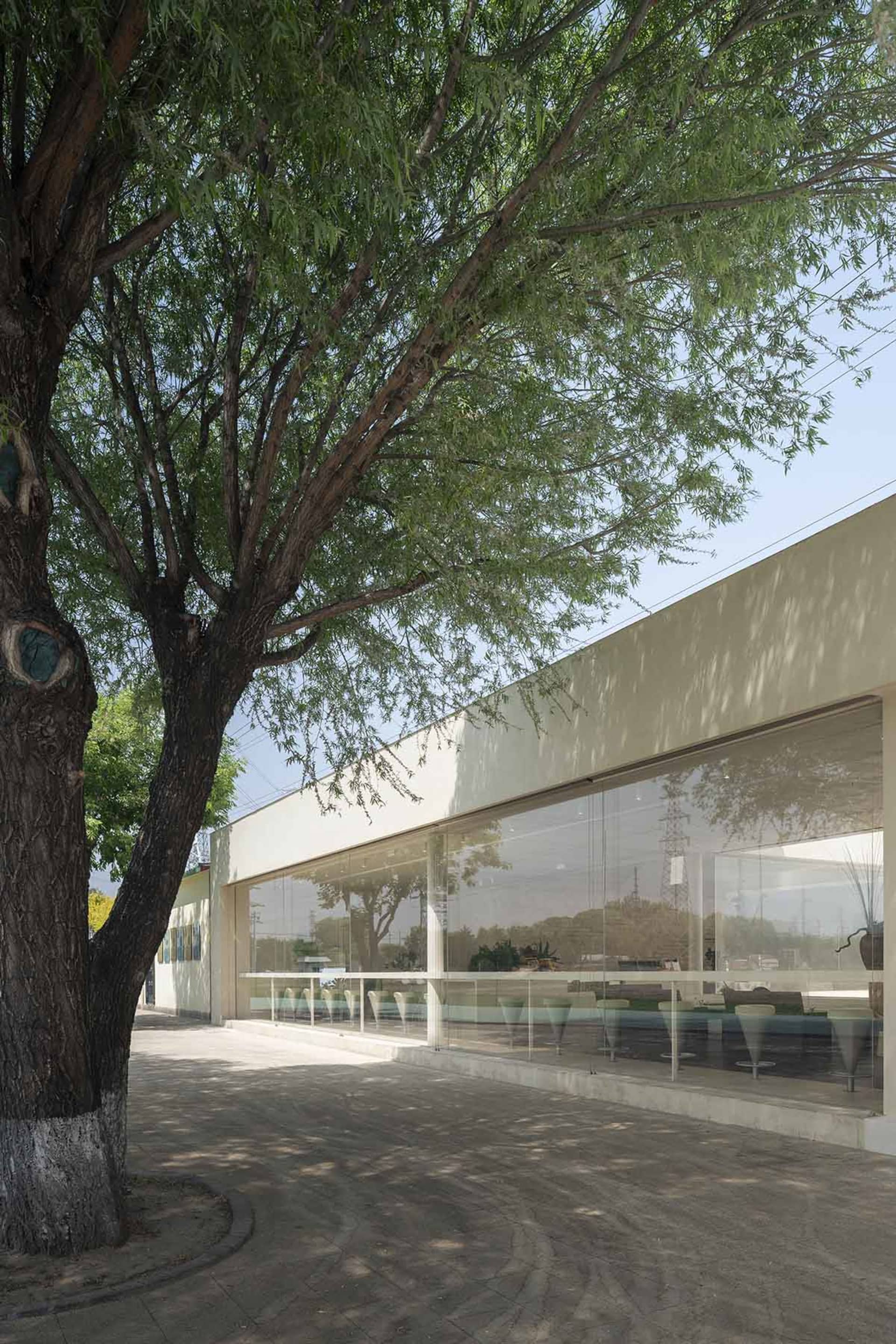 Modern commercial building with a glass facade and concrete elements.
