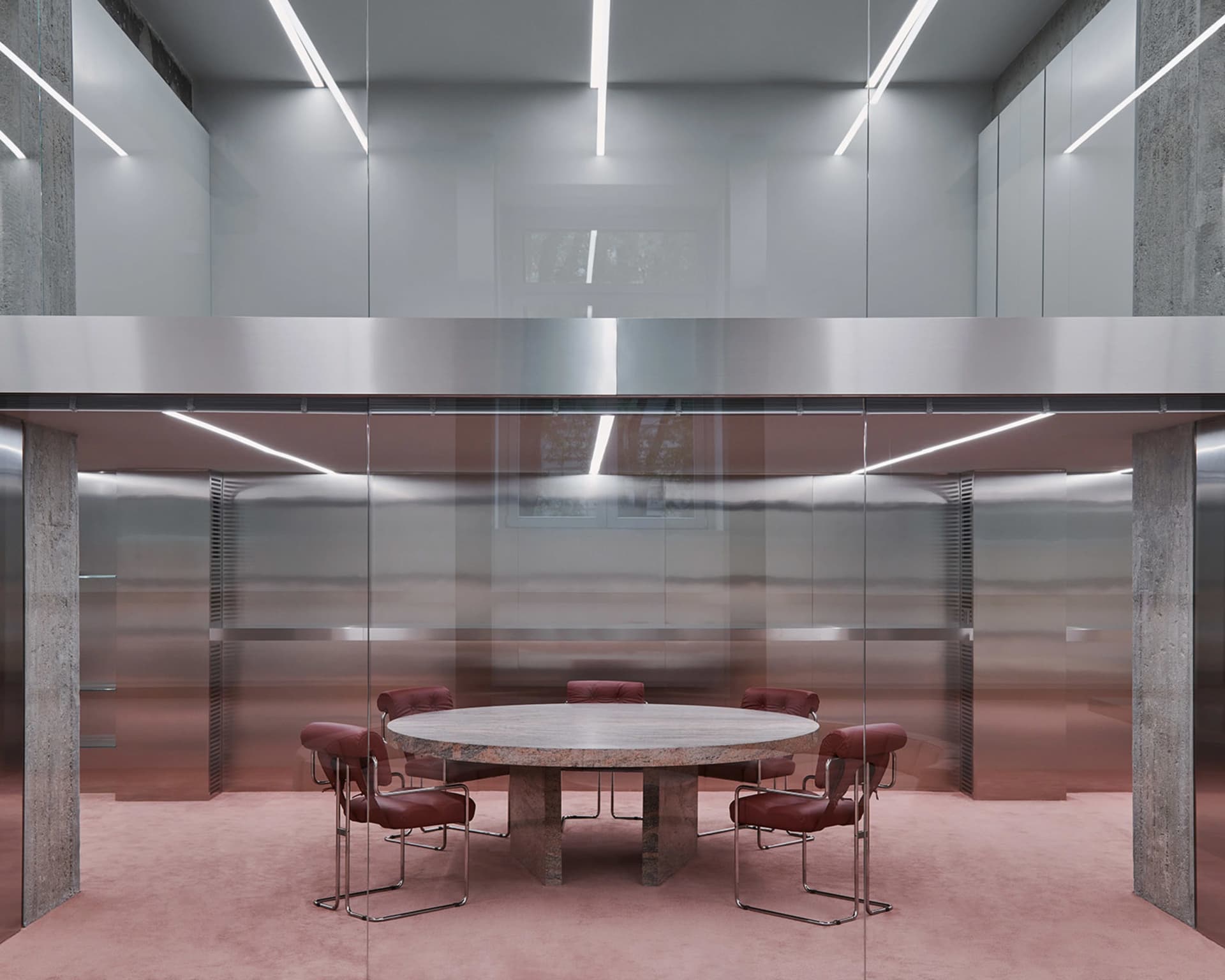 Modern office conference room with a marble table, glass walls, and concrete columns.