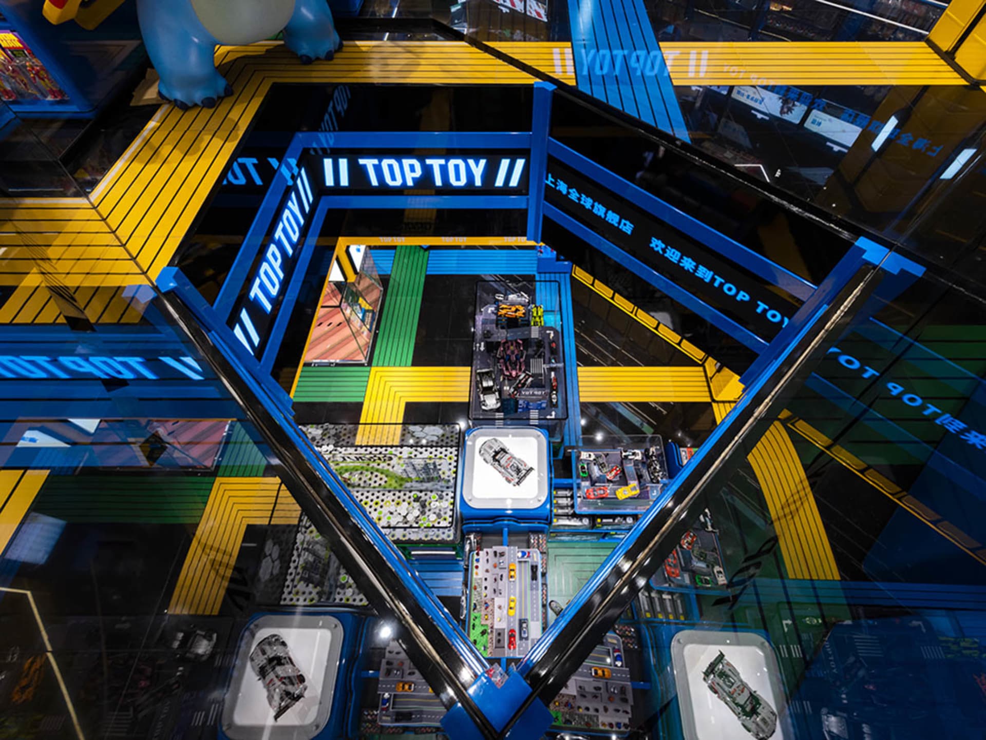 TopToy retail store with colorful glass and metal displays and plastic cars.