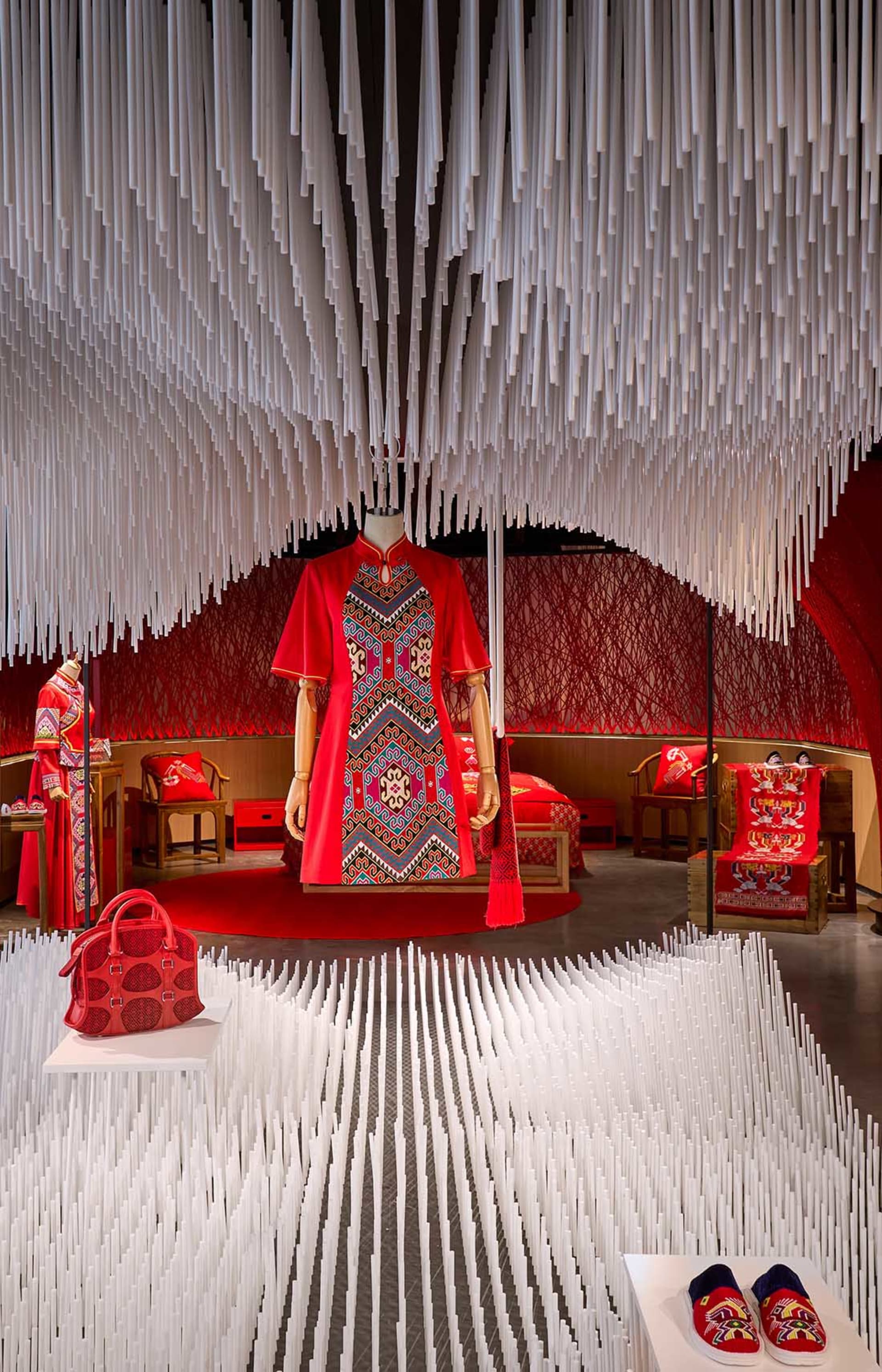 Fashion retail display featuring a red textile design with intricate patterns and traditional elements.