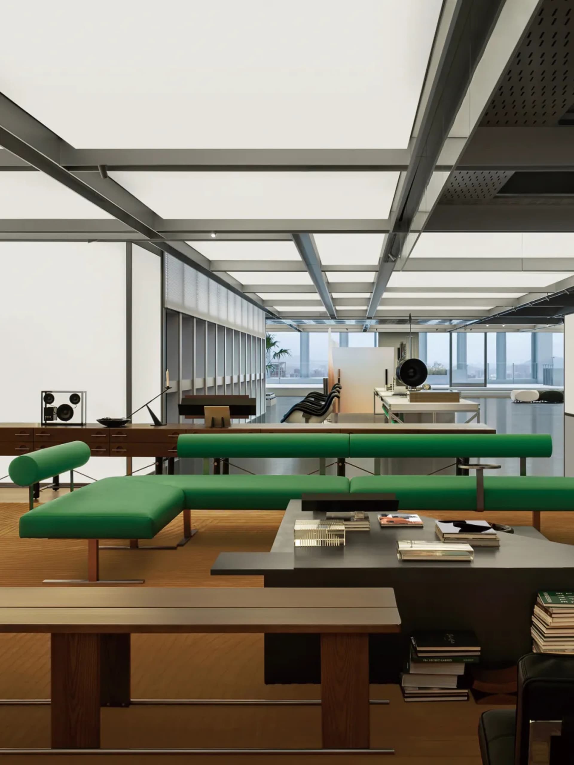 Modern office interior with green upholstered seating and metallic frame furniture.
