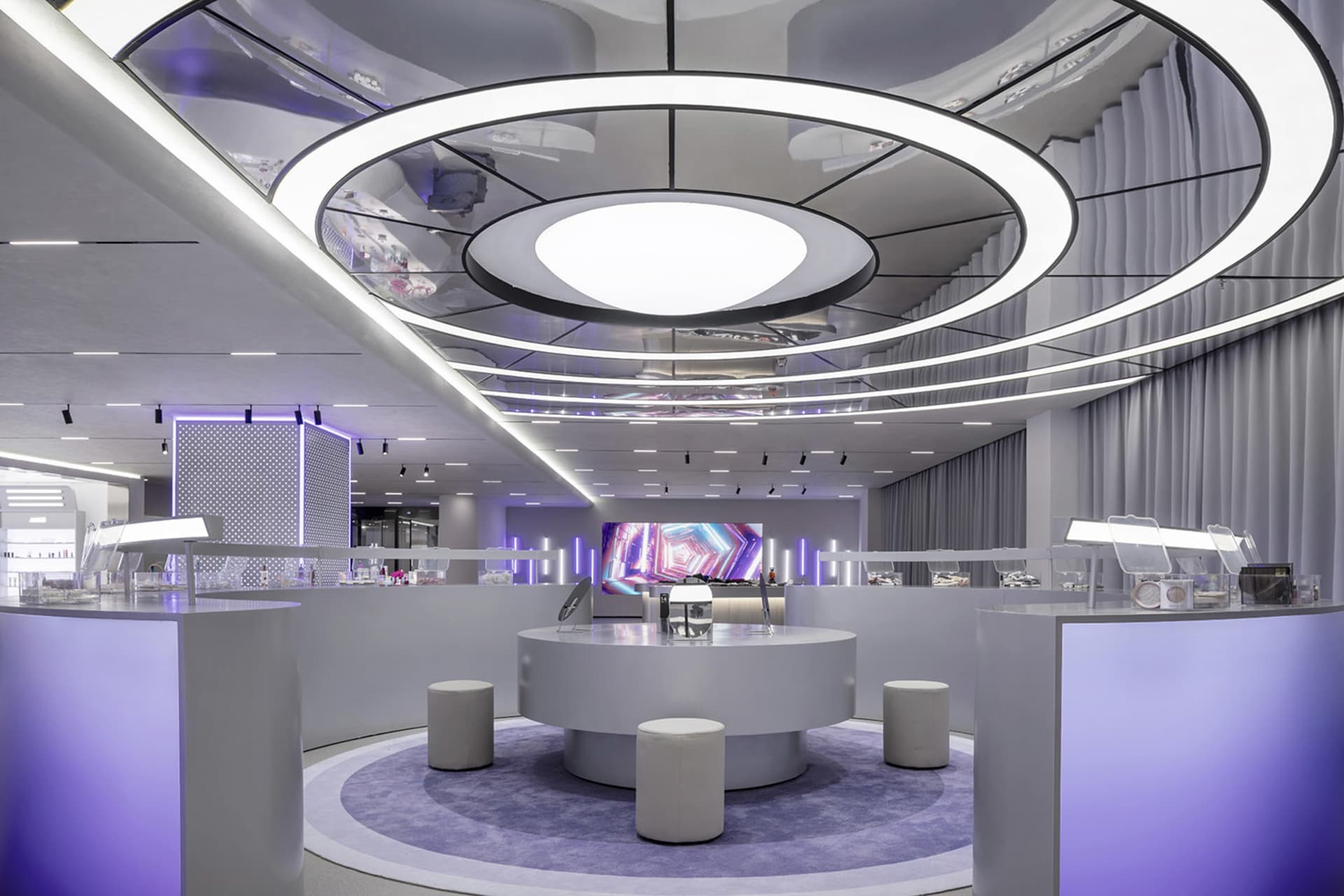 A modern retail store interior with glass displays, metallic accents, and fabric curtains.