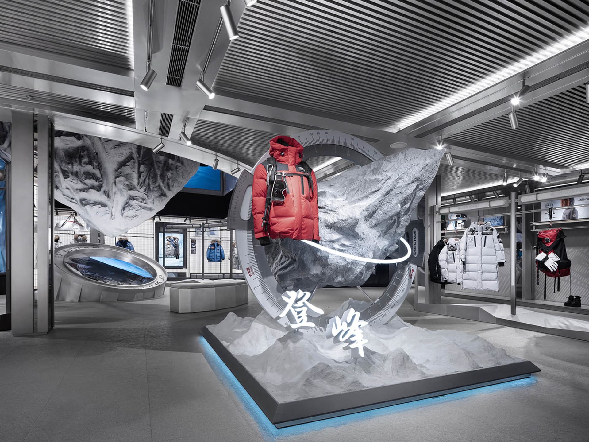 Fashion retail display featuring a red jacket mounted on a white mountain, surrounded by rock formations and a blue backgroun