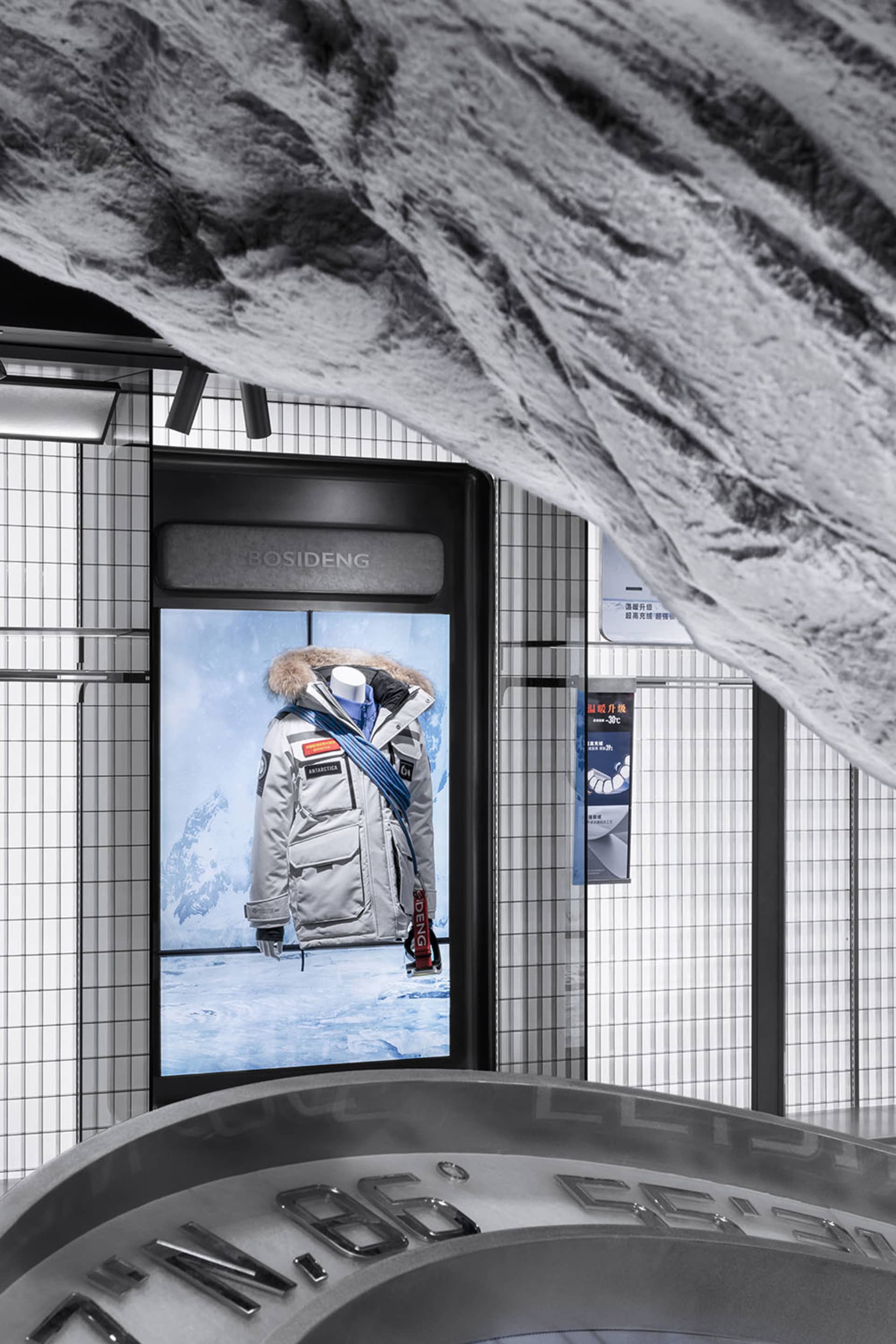 Modern retail storefront with duotone color scheme featuring a mannequin displaying a winter jacket with a fur-lined hood.