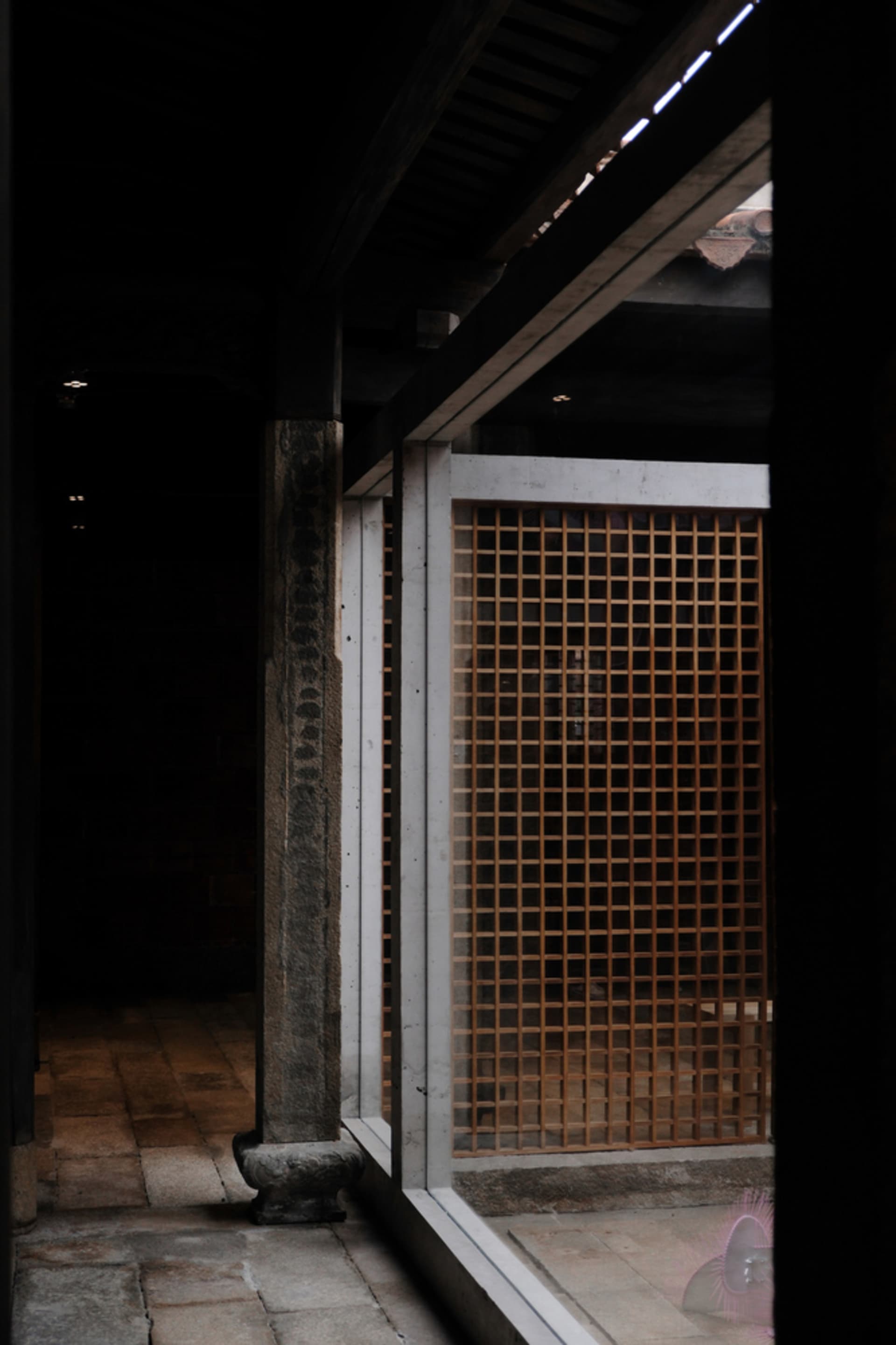 Concrete doorway with a wooden lattice window in an ancient structure