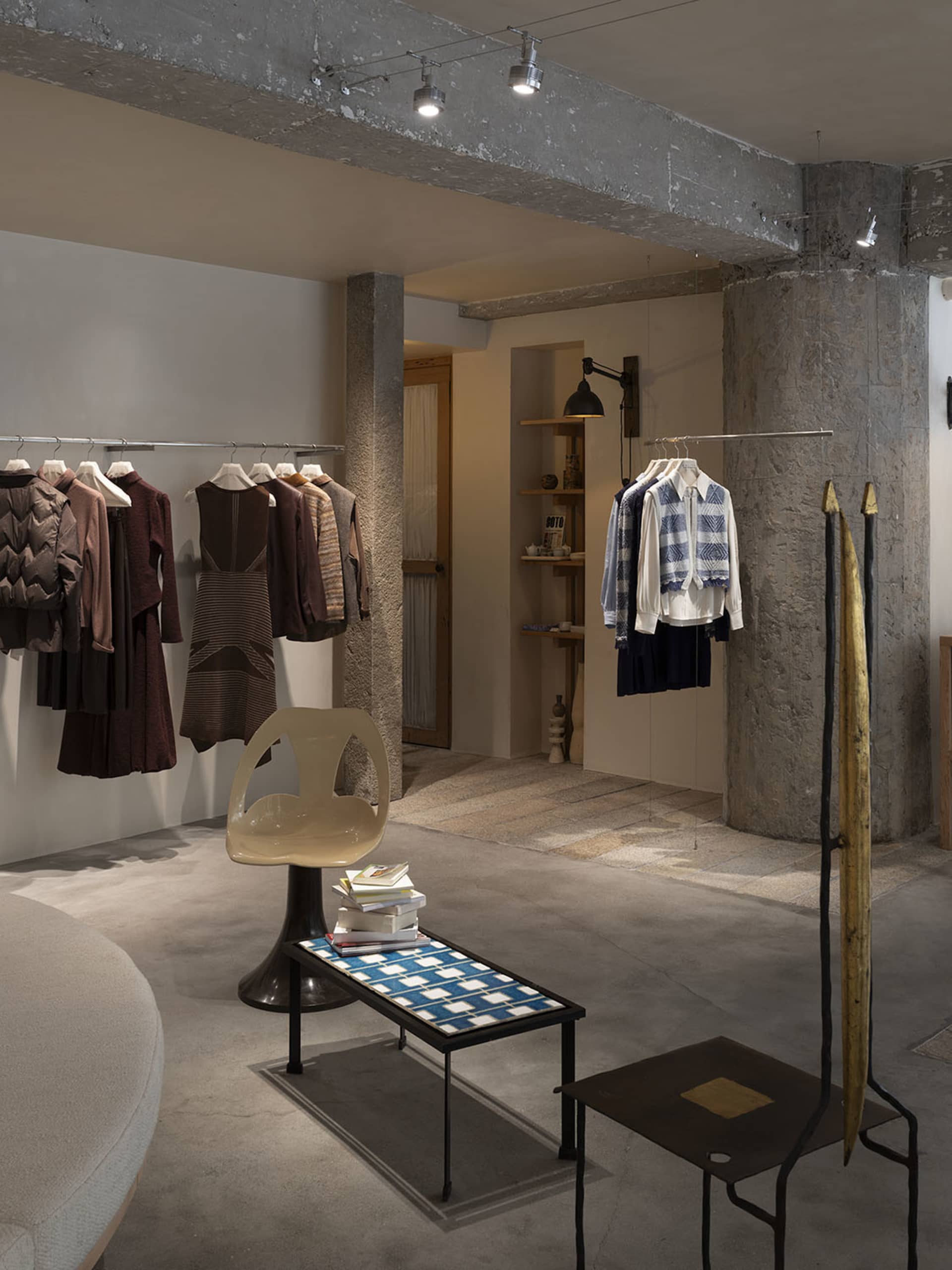 一間以工業設計為主的服飾店,擁有混凝土牆面、極簡家具與服裝展示架。