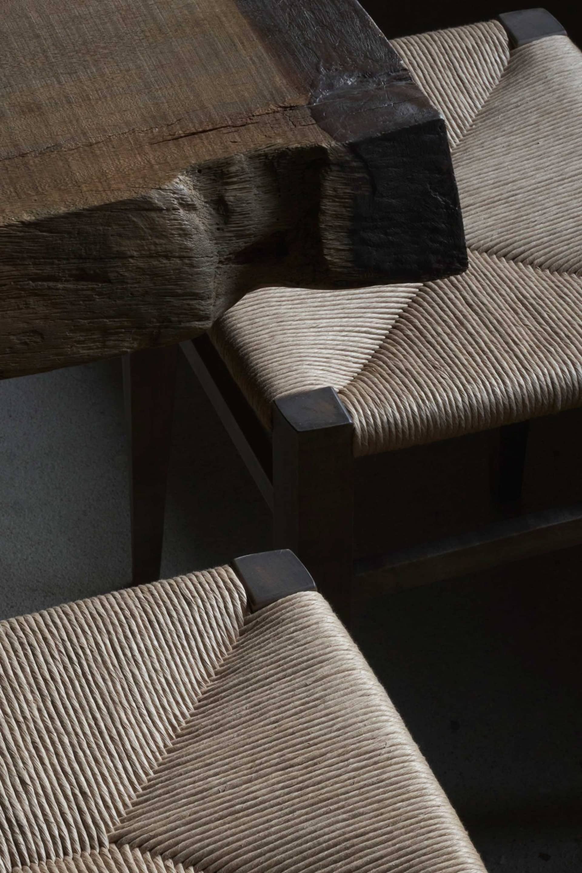 Close-up view of industrial-style furniture featuring wood and woven rope seating