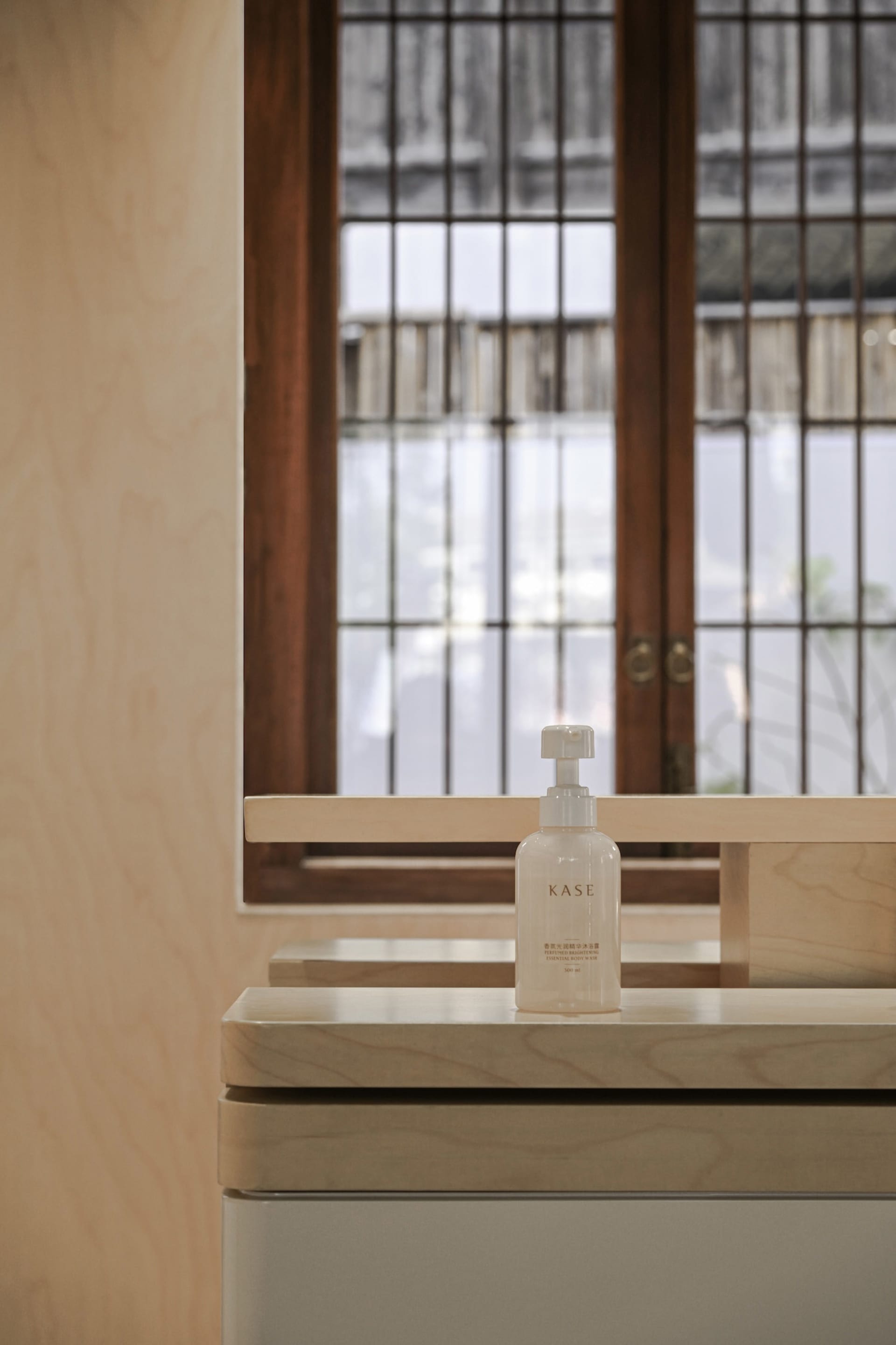 A clean, modern bathroom with a wooden vanity and window.