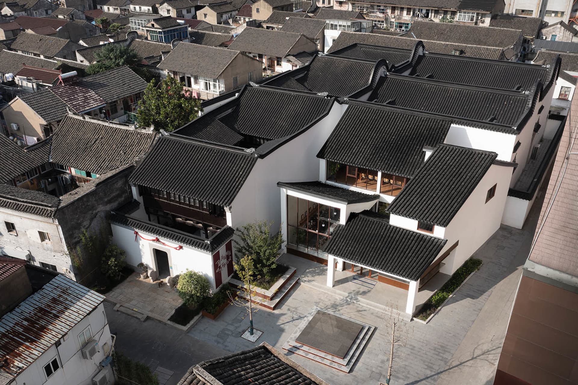 俯瞰傳統中式房屋,屋頂覆蓋陶土瓦片,白牆搭配木樑結構。