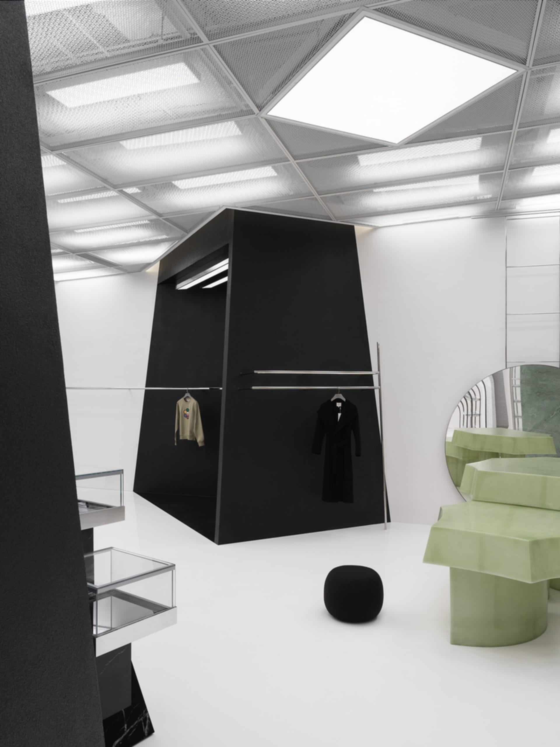 A modern clothing store with black and white interiors, featuring minimalist design and glass elements.