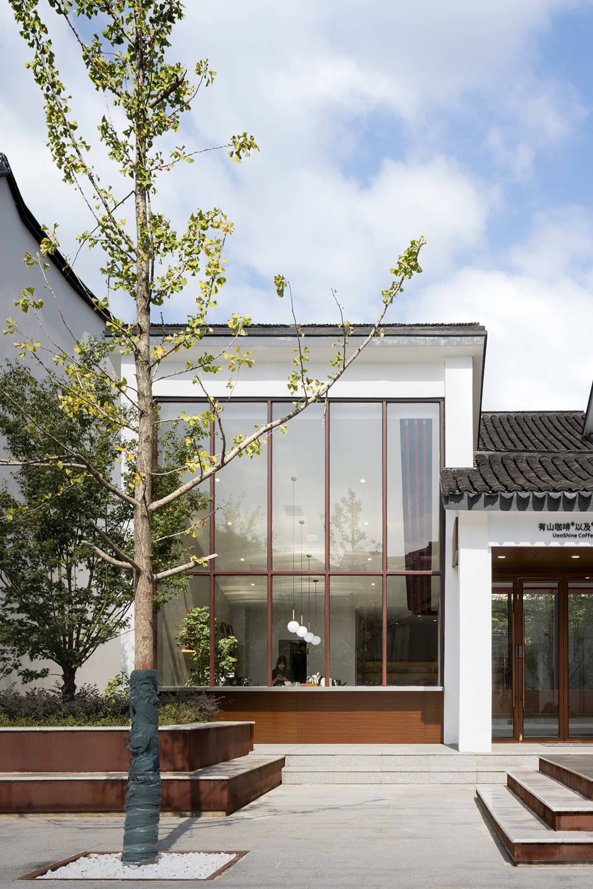 Modern building with large glass windows and traditional roof tiles