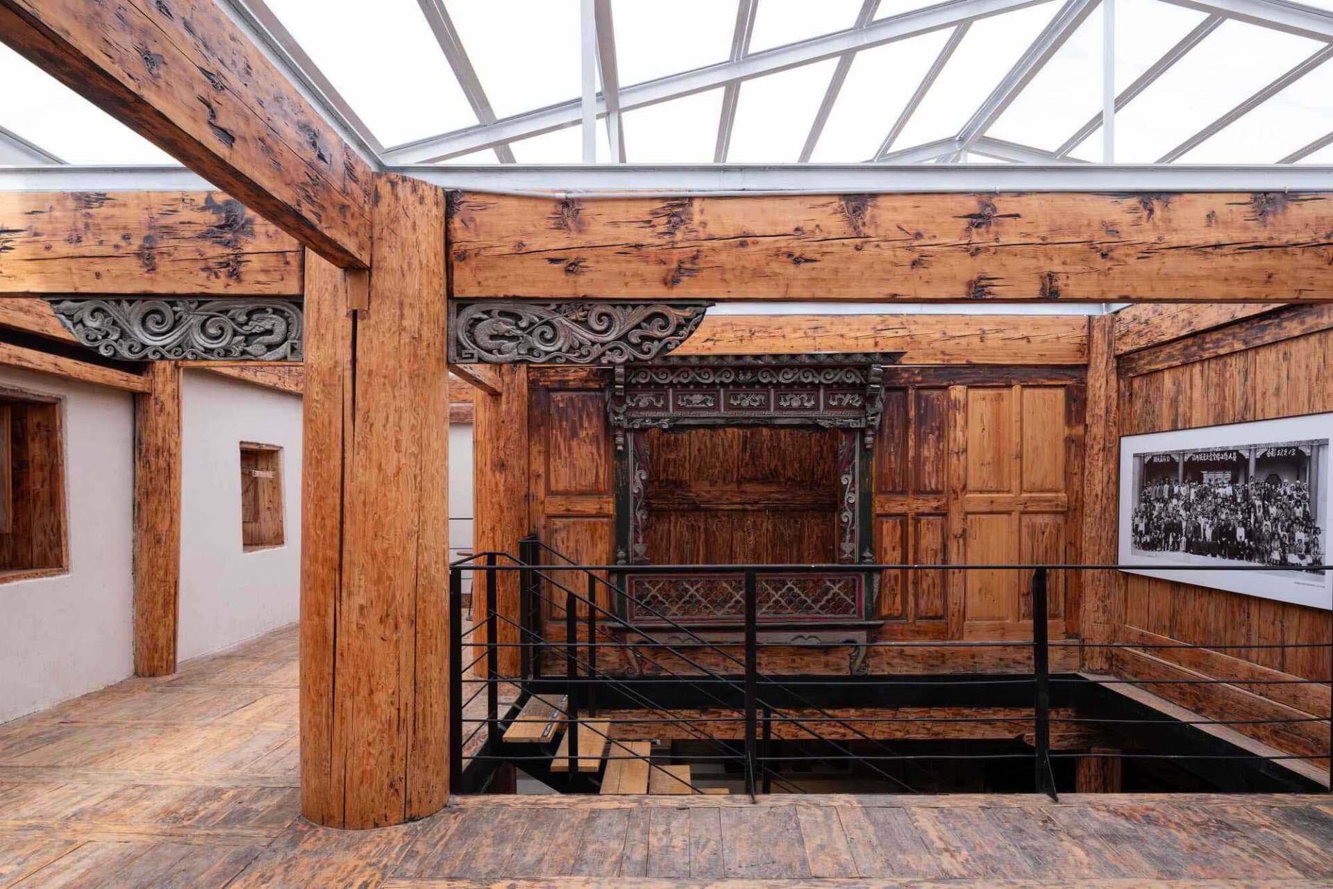 Interior of a traditional wooden teahouse with intricate carvings and glass roof