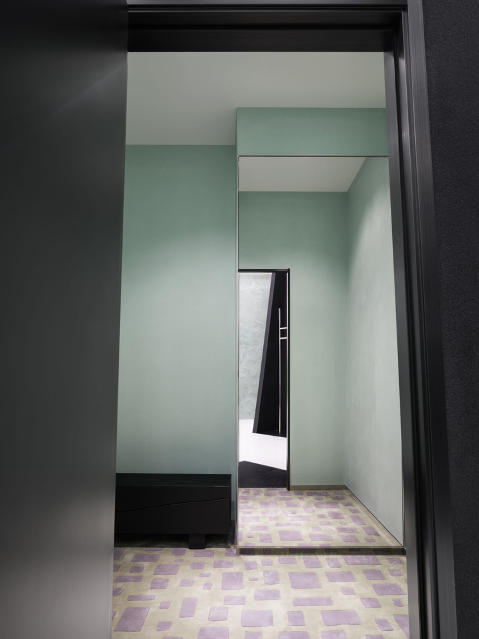 A modern entryway featuring cement floor tiles and carpeted flooring.