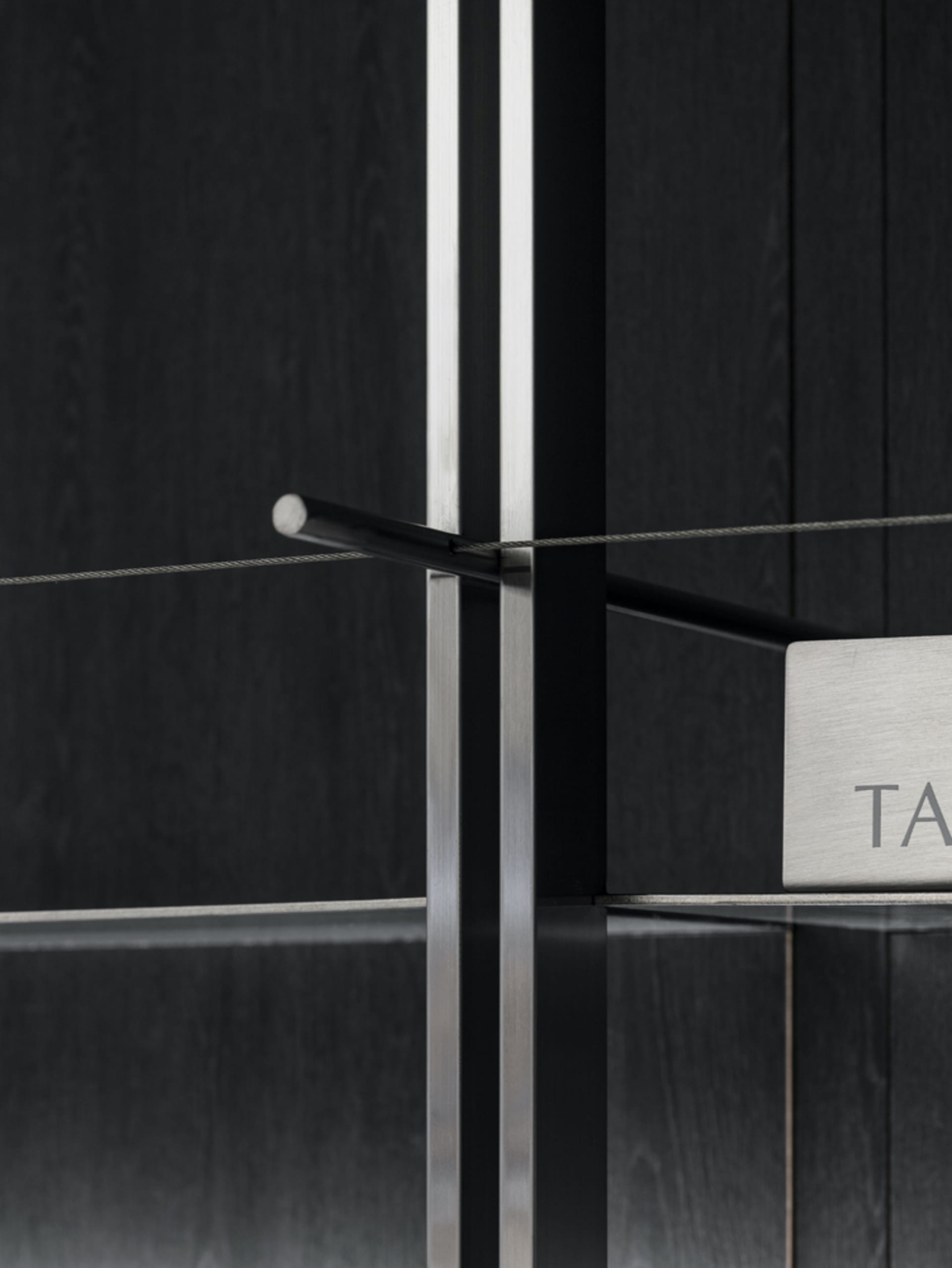 Close-up of modern metal furniture with glass shelves.