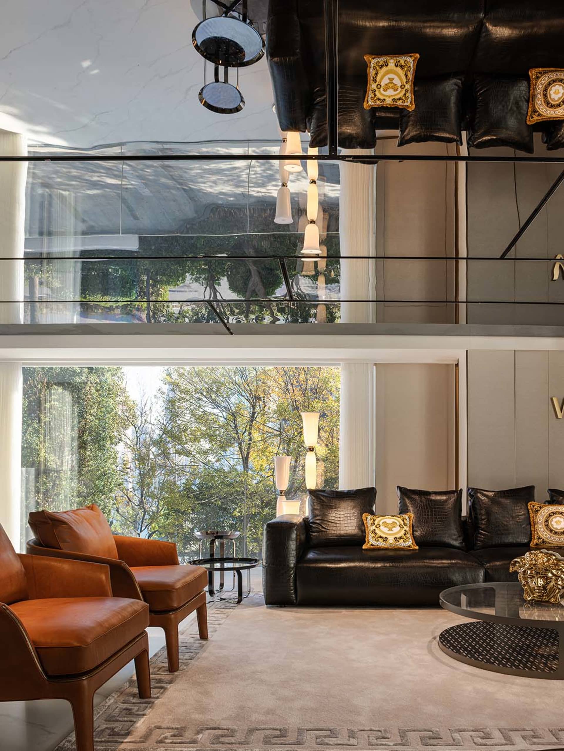 A modern living room with leather furniture, glass tables, marble accents, and wooden elements.