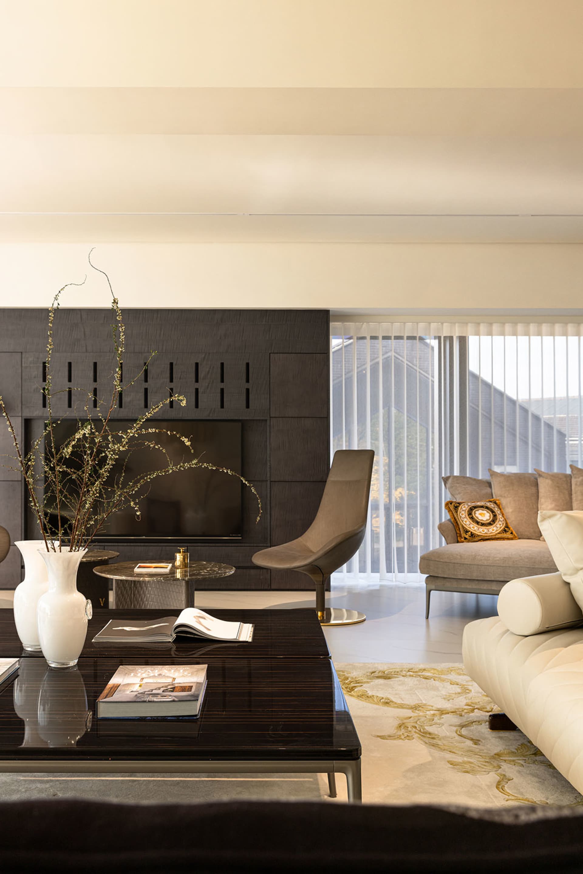 Modern living room with dark wood coffee table, white sofas, and minimalist art.