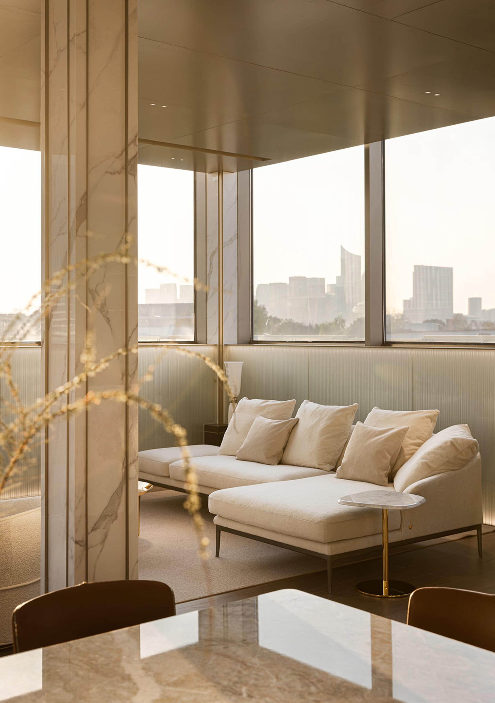 Modern living room with marble walls, concrete floor, and cloth furniture.