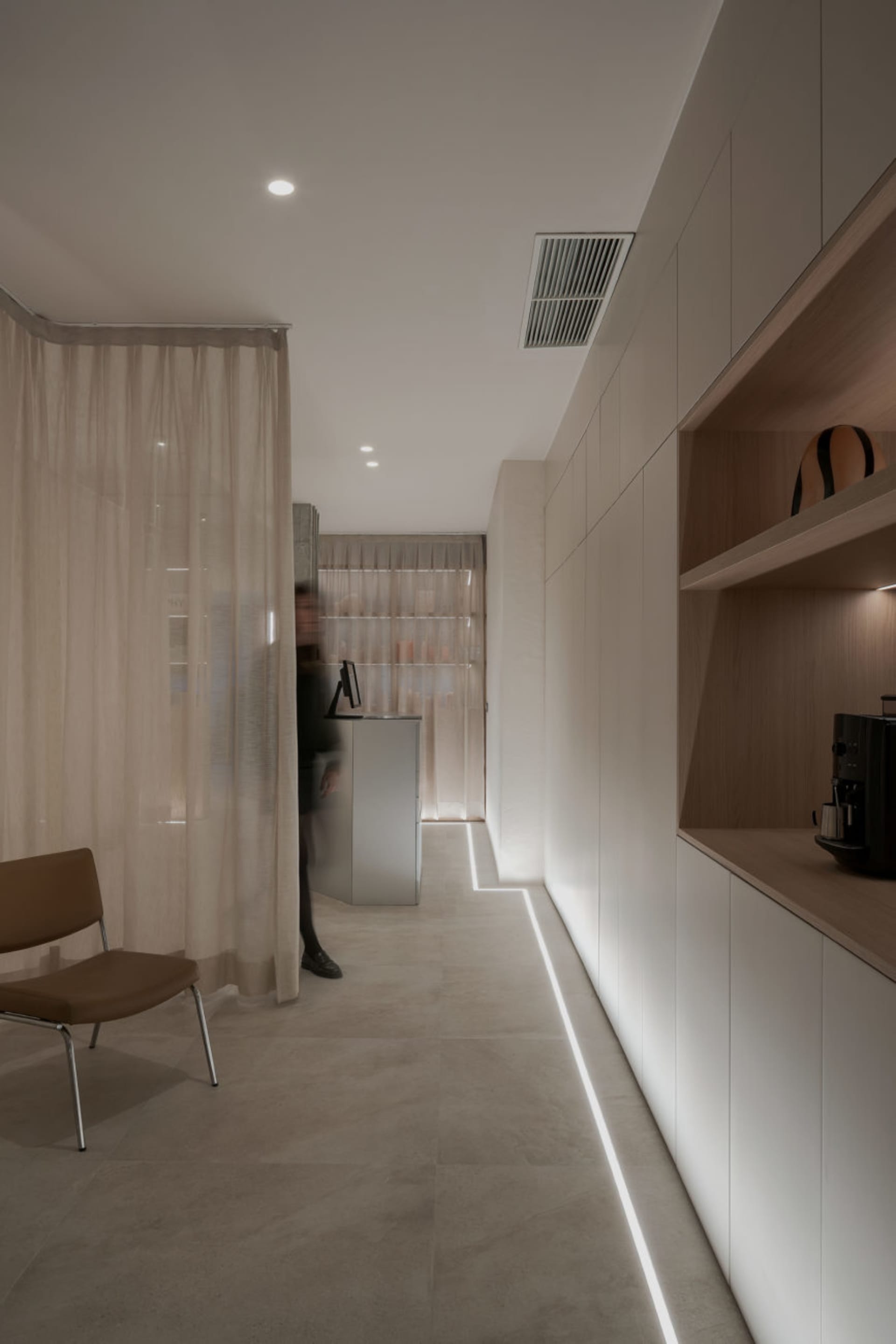 A minimalist living room with white walls and wood furniture, emphasizing the simplicity and elegance of the design.