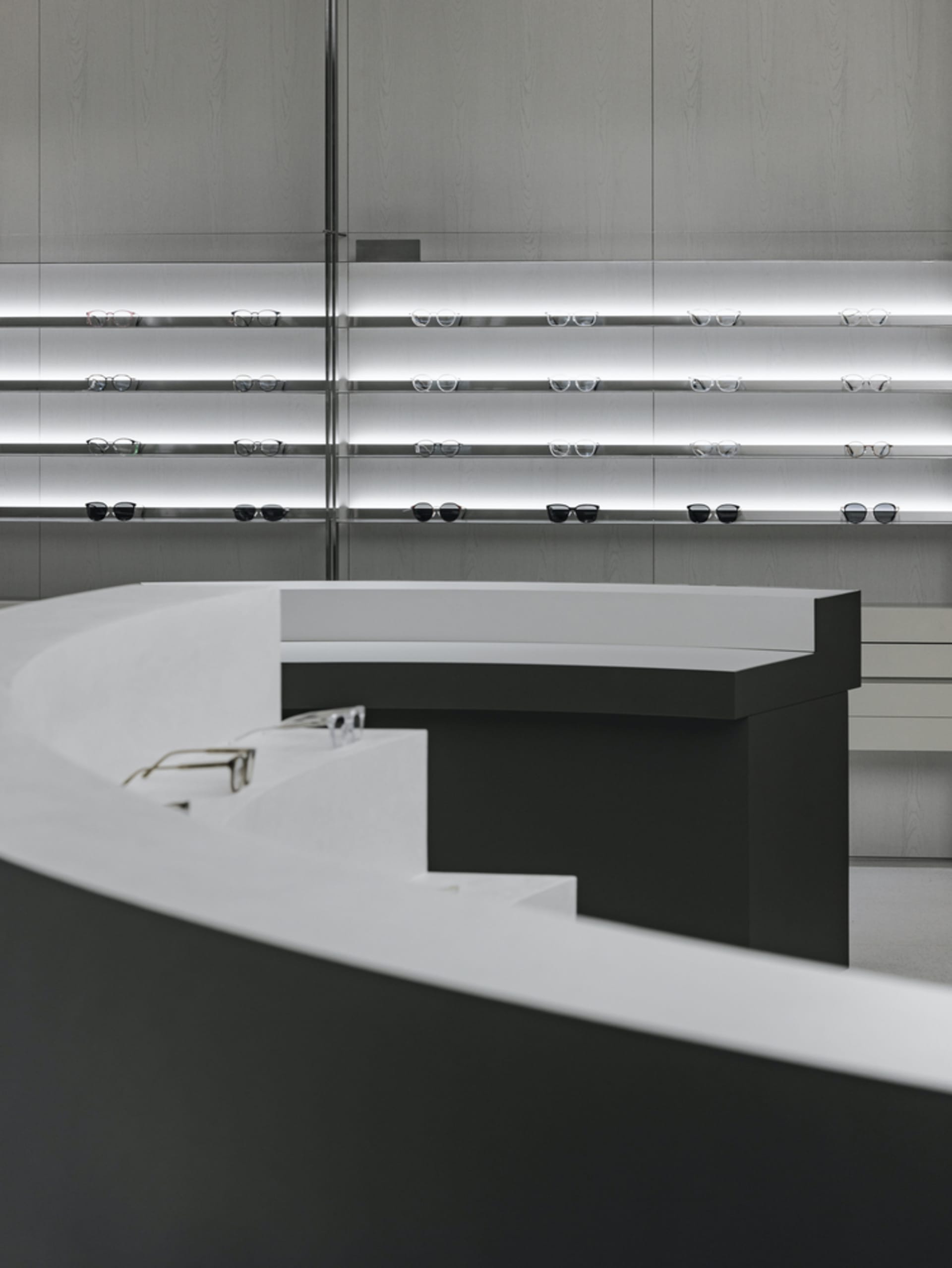 Modern retail space featuring metal shelves with glasses displayed