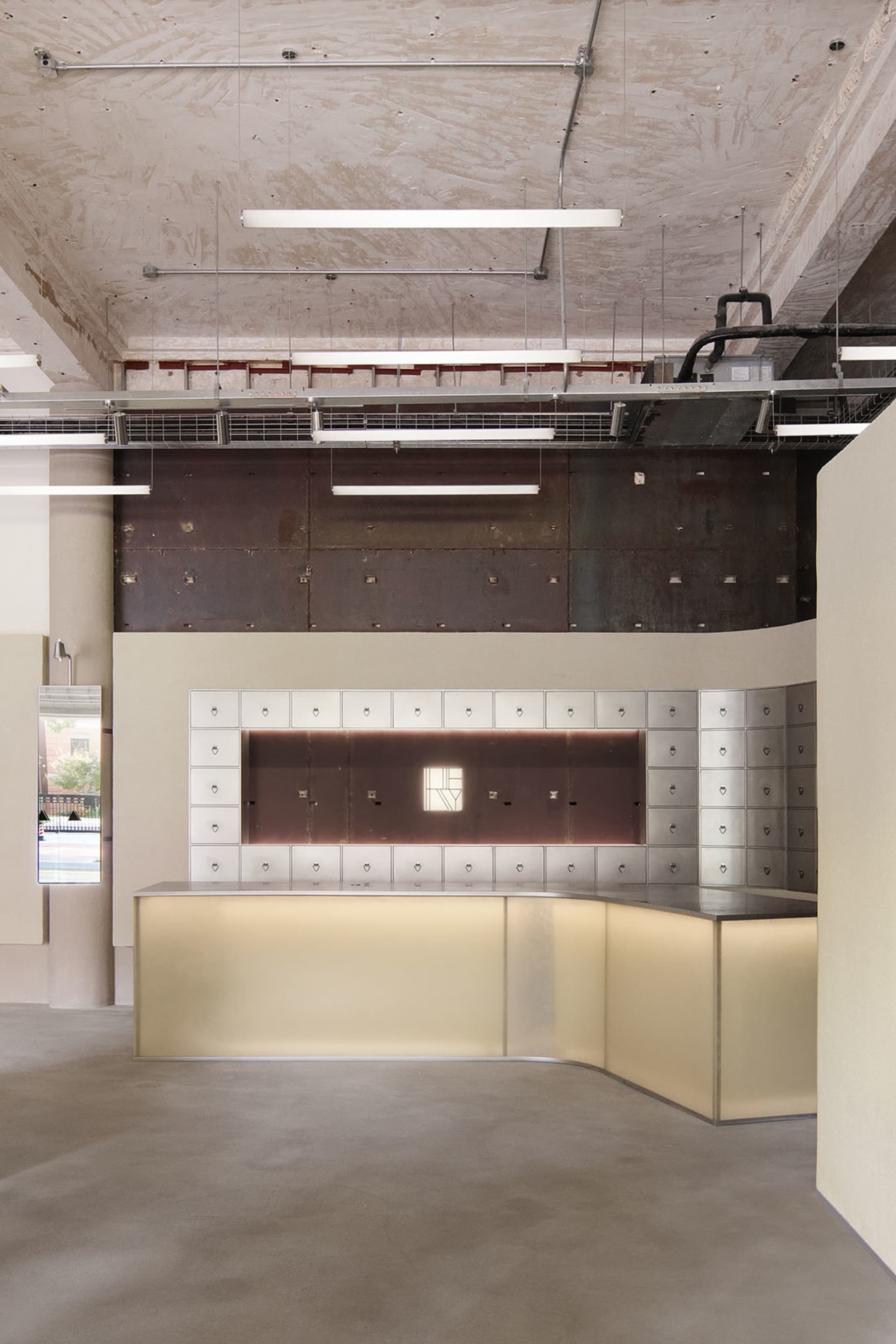 Modern office space featuring concrete walls and floors, minimalist design elements.