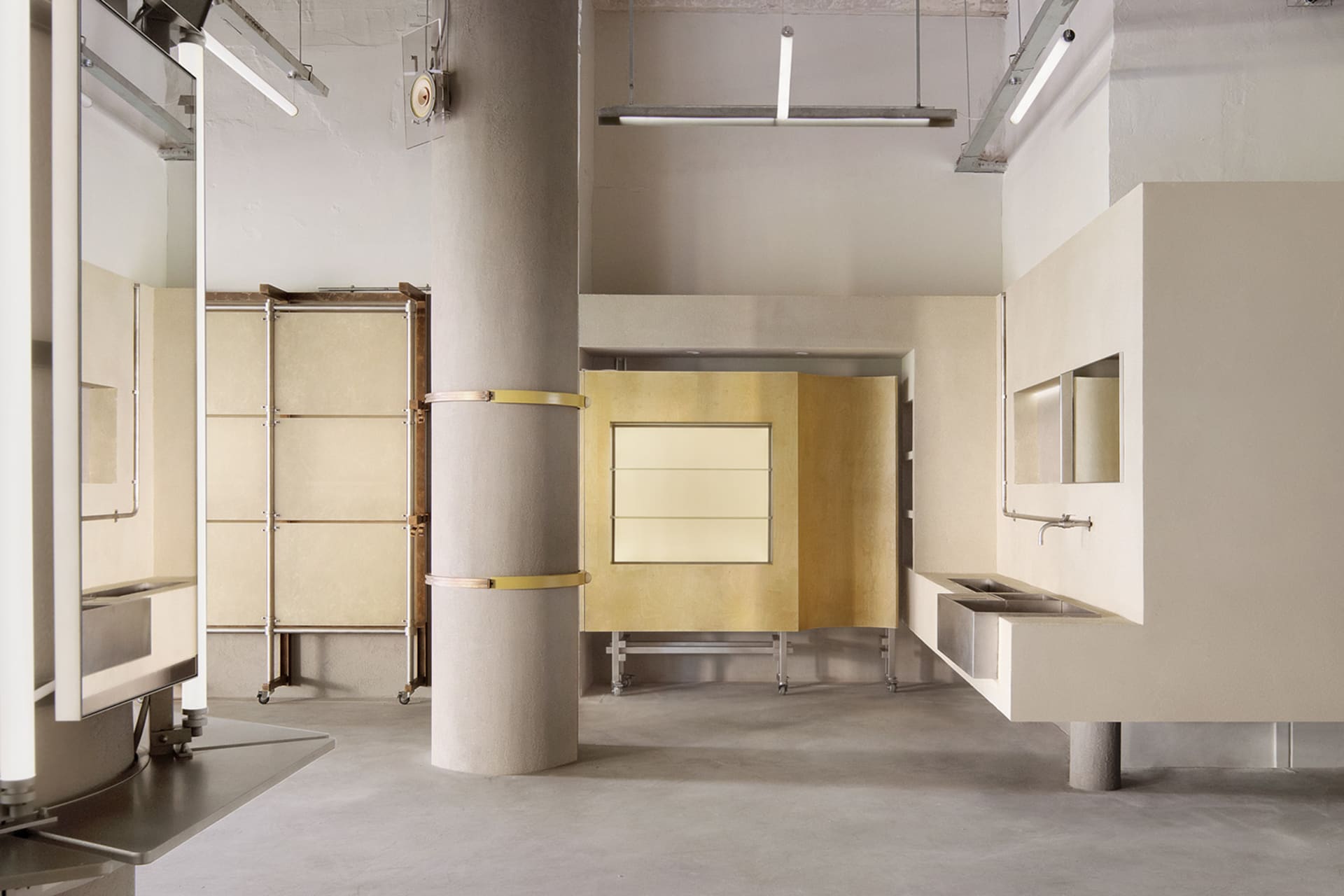 Minimalist bathroom with concrete walls, glass wall, and brass accents.