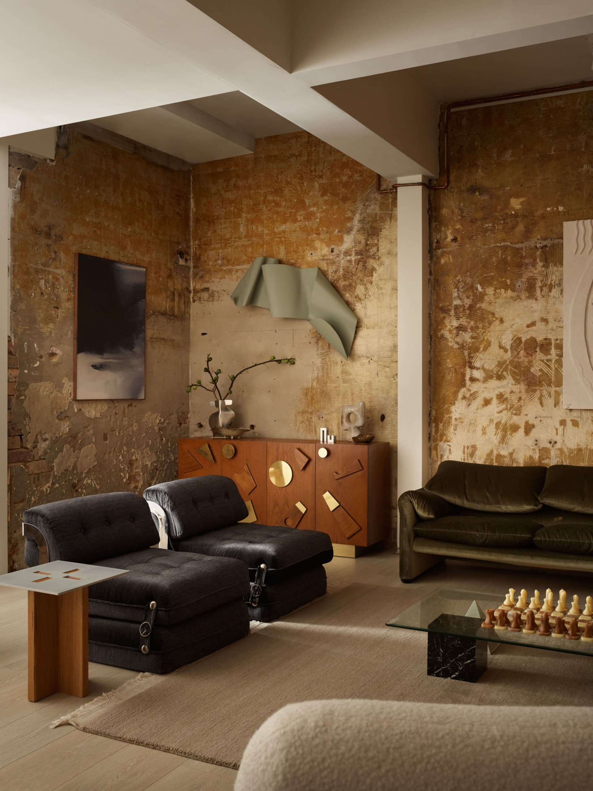 Industrial living room featuring metal and wood furniture and concrete walls.