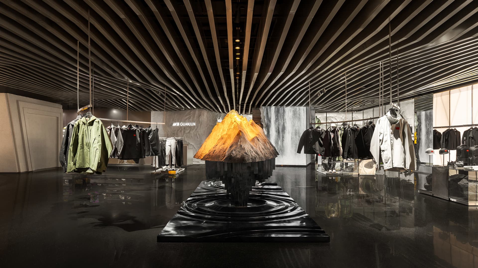 A modern retail store interior featuring metallic materials and a prominent volcano sculpture.