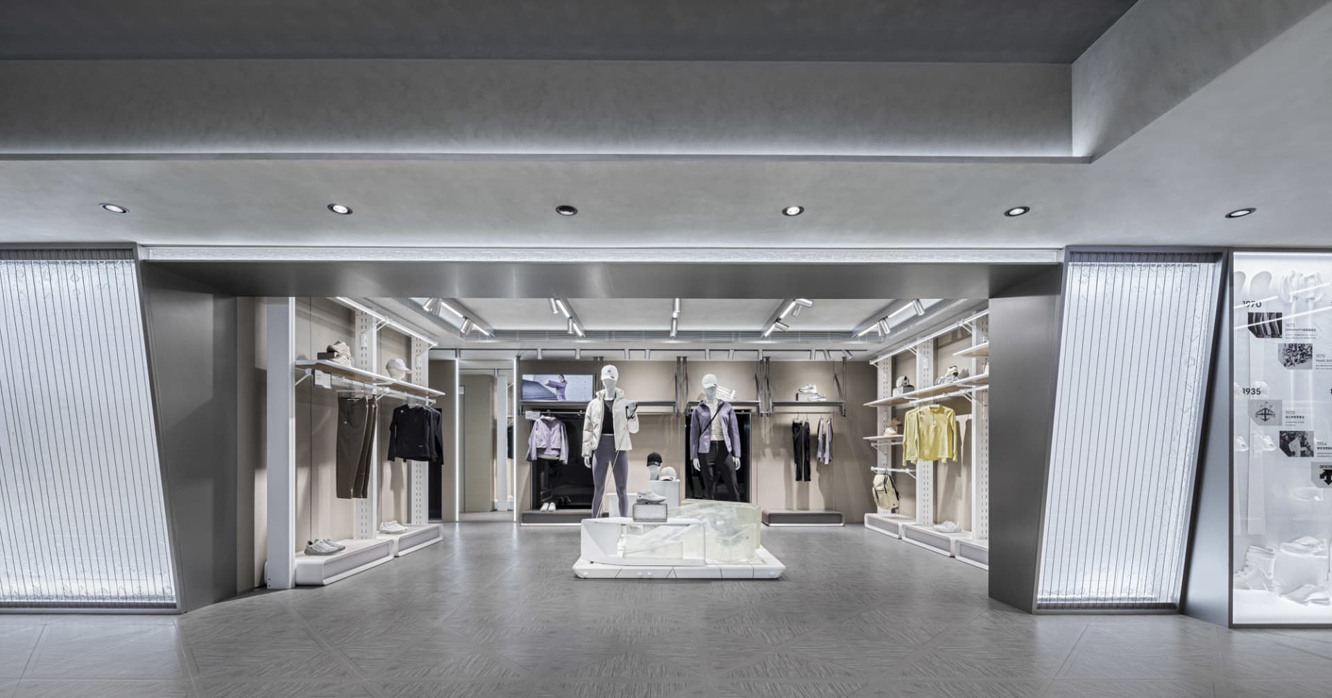 現代零售店內部採用混凝土與金屬材質,展示服裝於人體模型上。