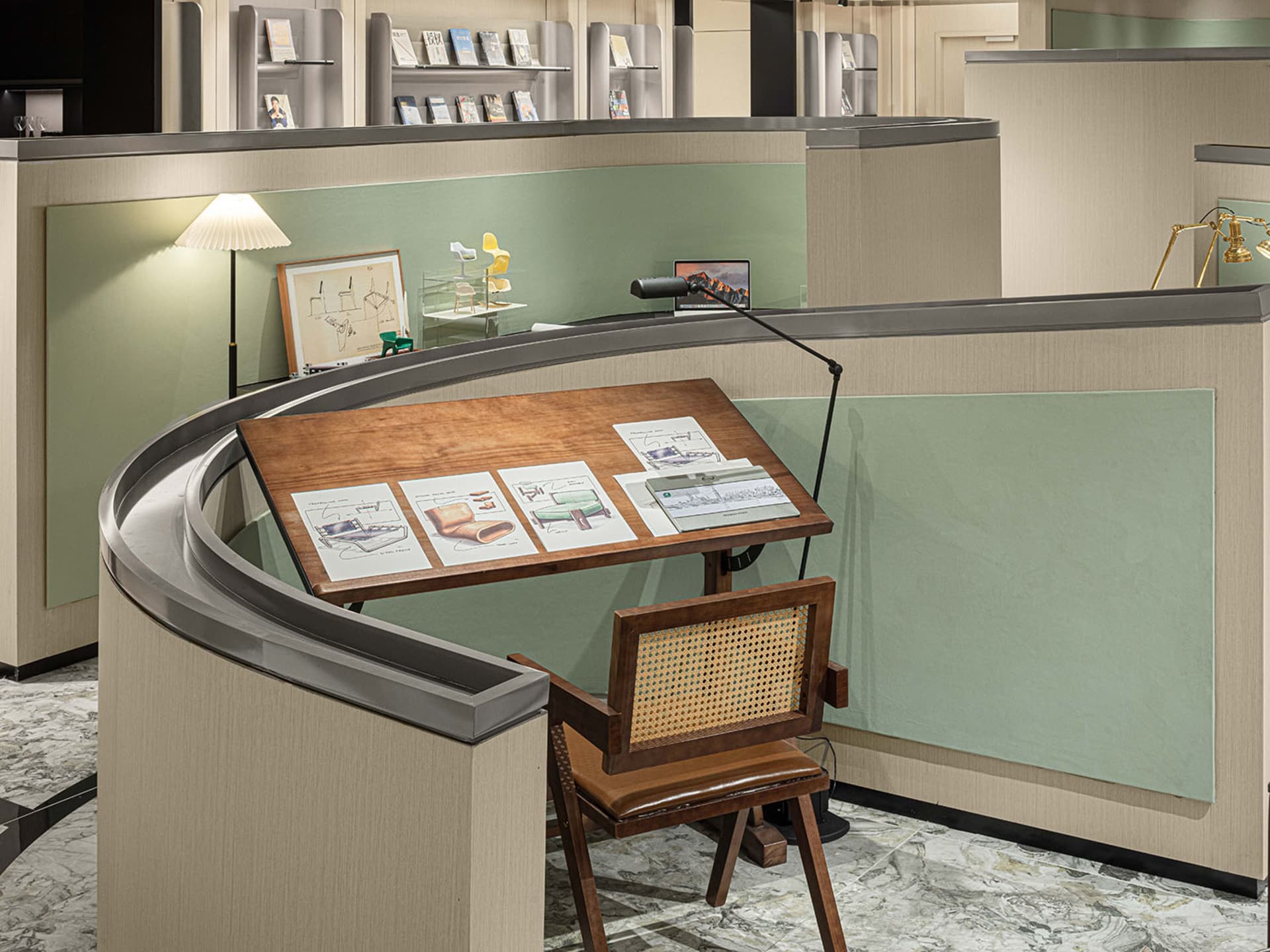 Industrial office space featuring a wooden desk with drafting tools and a lamp.
