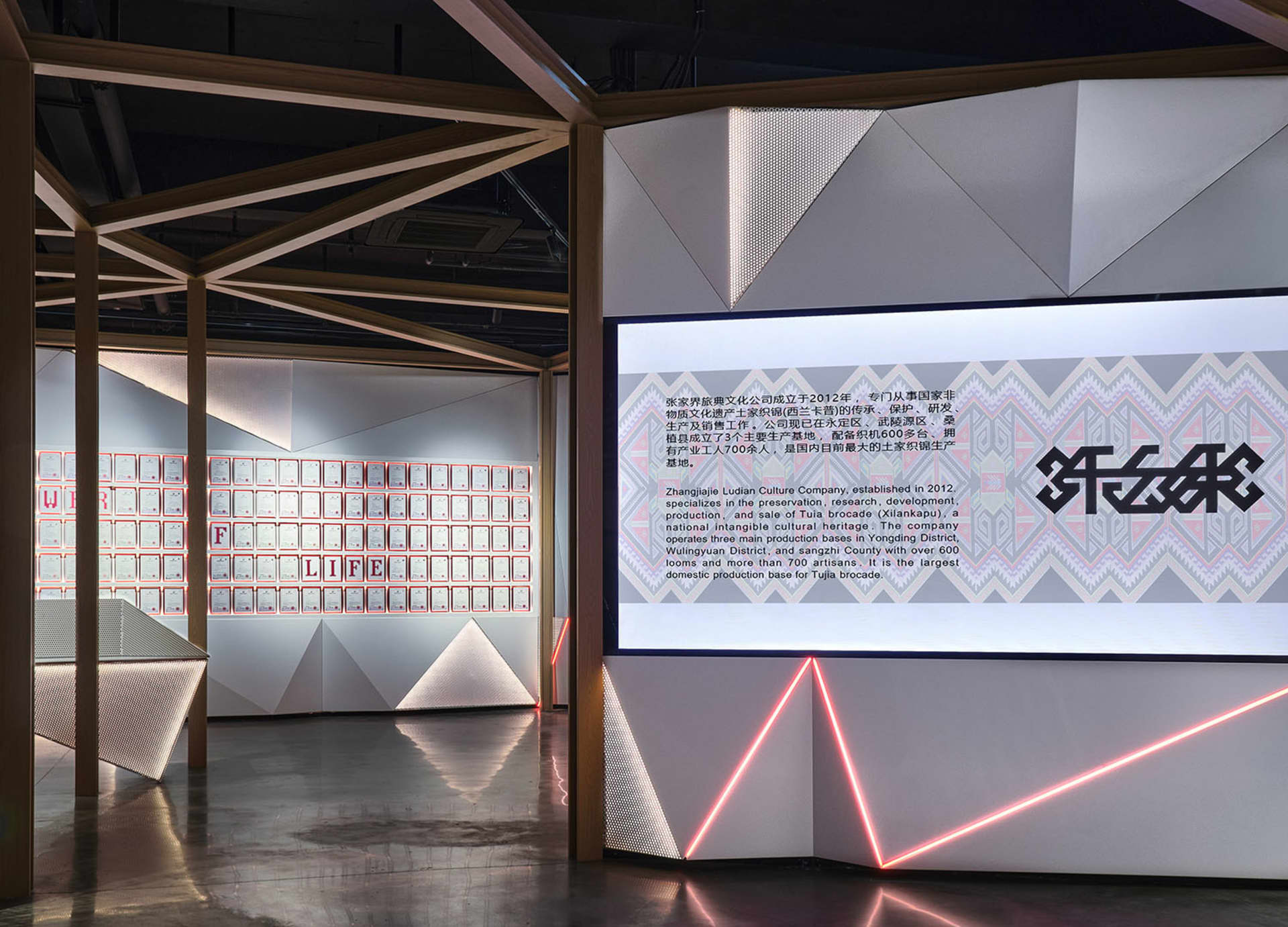 A spacious, modern interior with metallic-textured walls and a large screen displaying text and images.