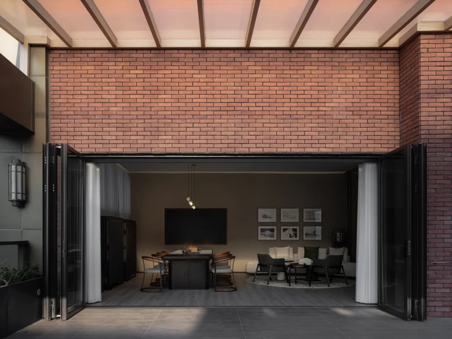 A modern living room with brick walls, featuring dark furniture and a large window.